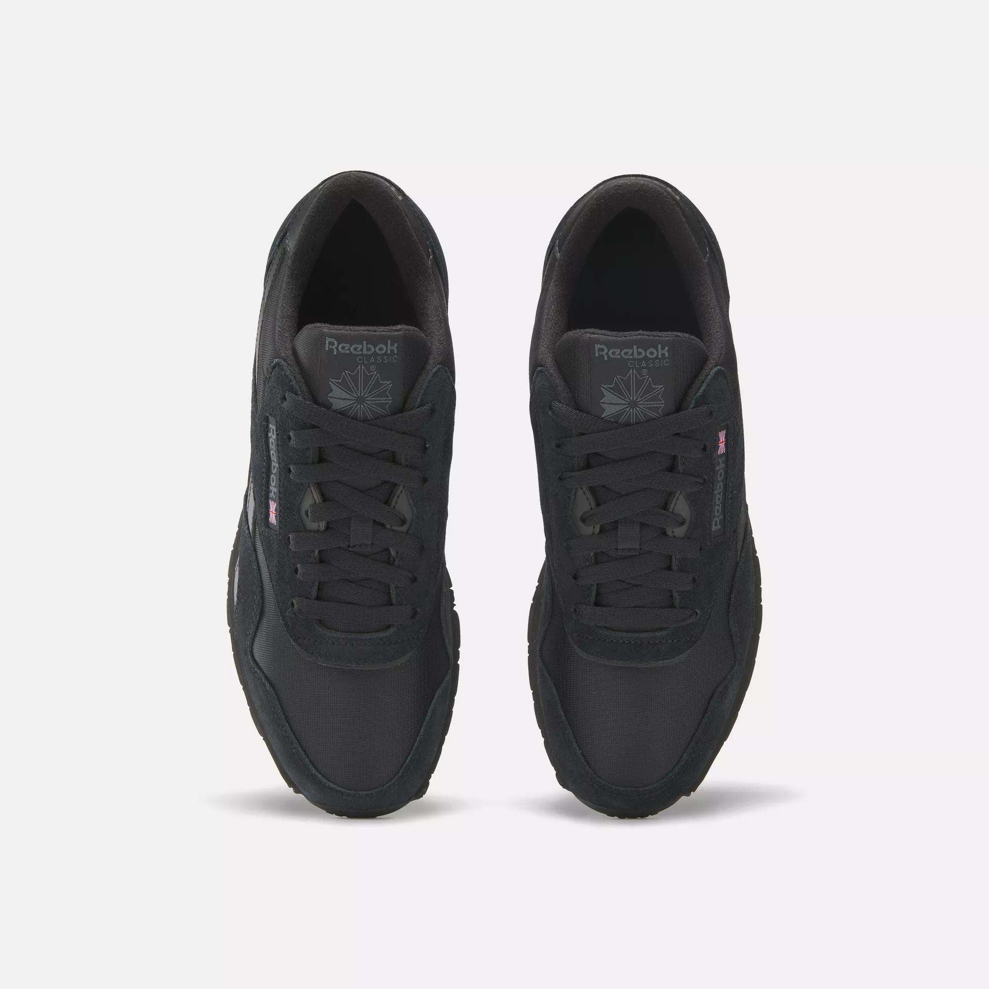 A pair of Men's Classic Nylon Shoes by Reebok, shown from above on a white background, features a black nylon upper, laces, tongue logo, and subtle side branding.