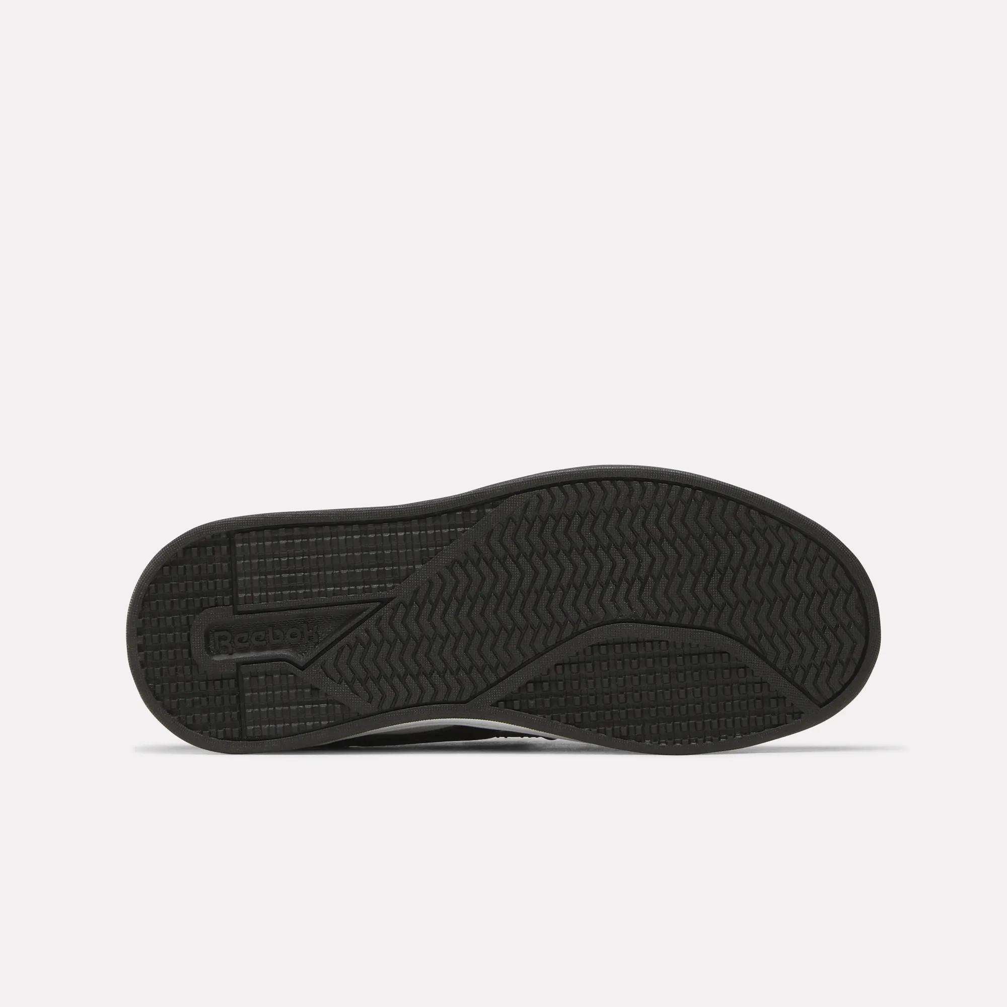 The image shows the sole of a black Kids' Reebok Royal Prime 2 Shoe featuring textured grip patterns and the Reebok logo on the left side, set against a plain white background.