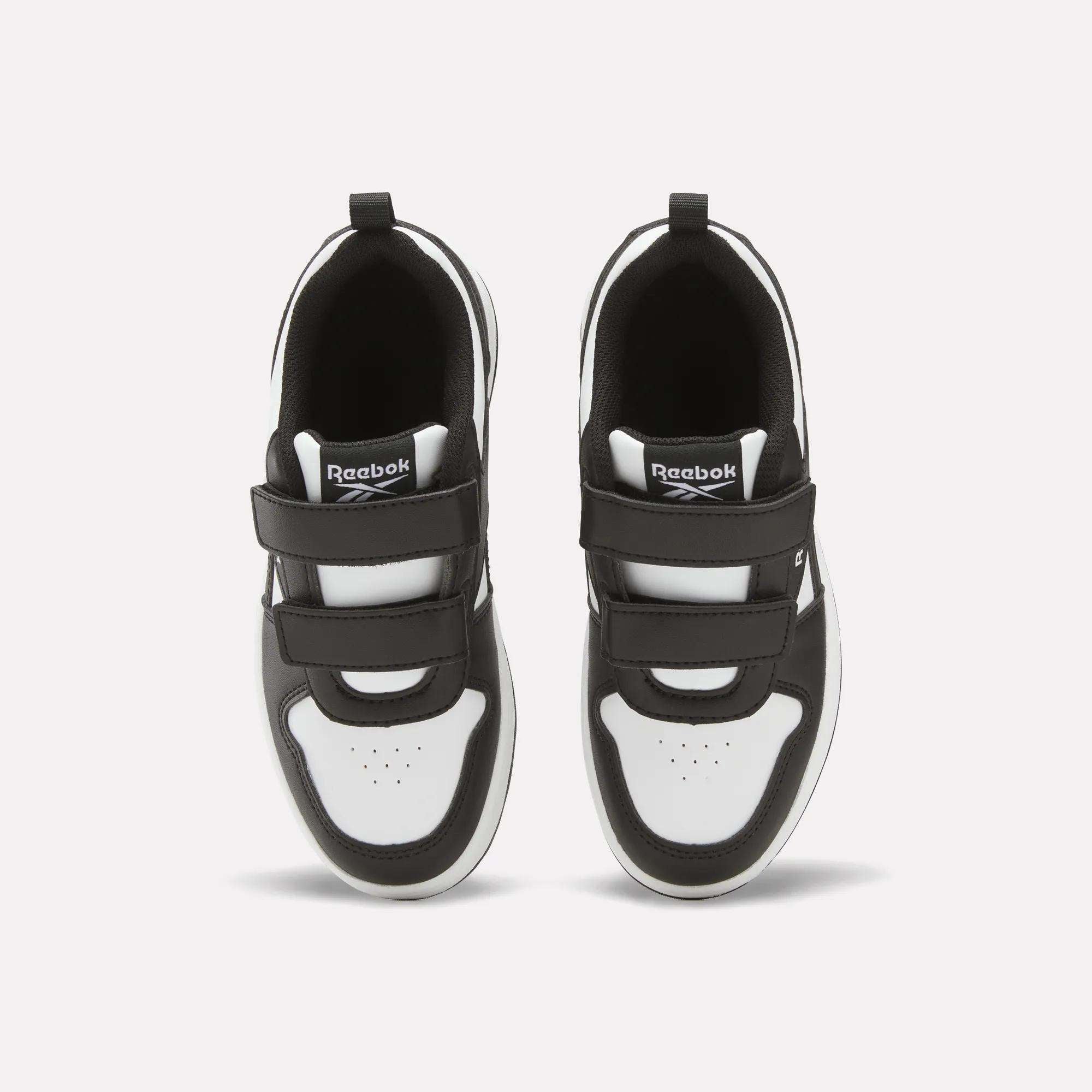 A pair of black and white Kids' Reebok Royal Prime 2 Shoes - Little Kids with hook-and-loop straps, seen from above, feature the Reebok logo on the tongue and perforated toe box detail.