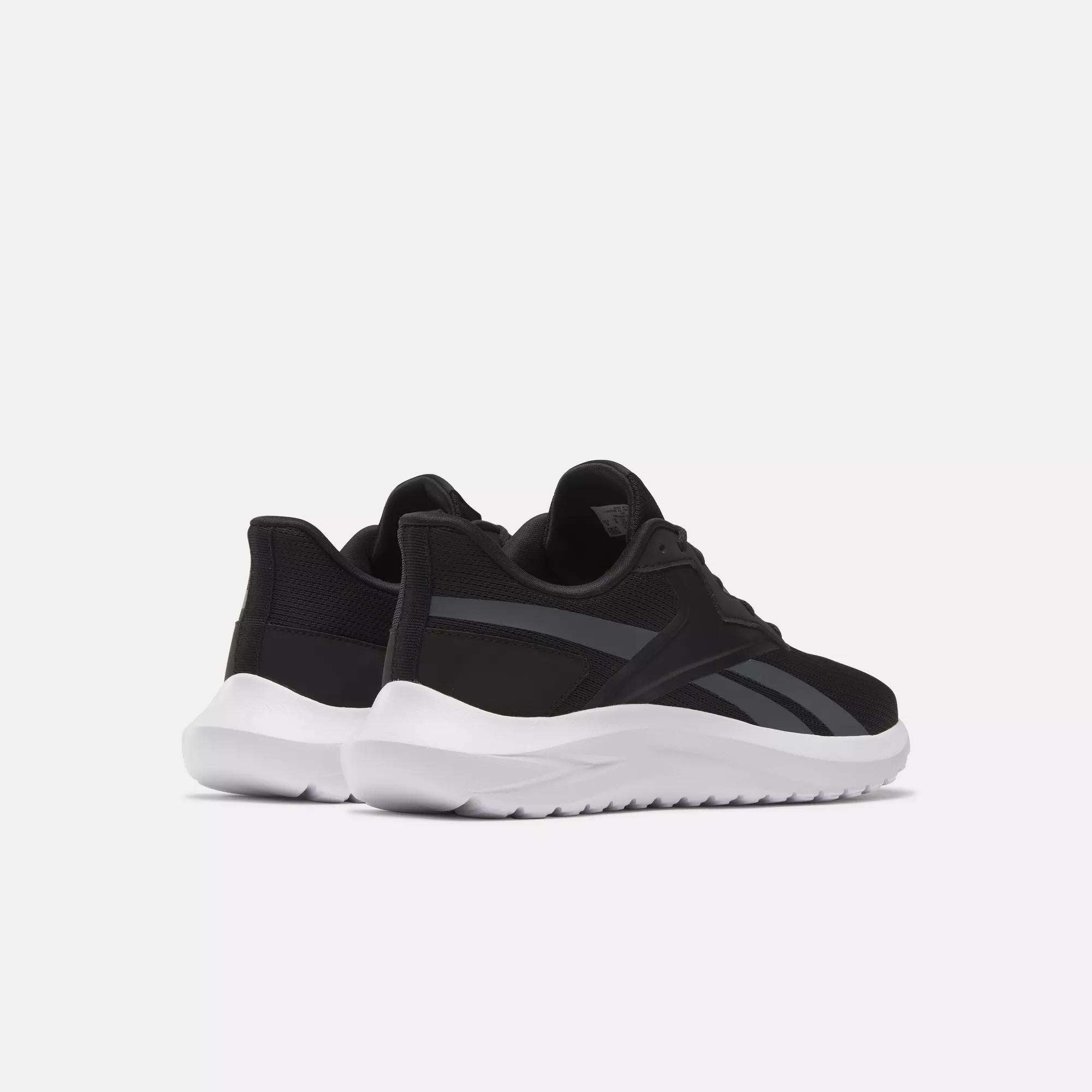 The Reebok Men's Energen Lux Running Shoes feature a versatile black design with dark gray stripes and thick white soles, displayed at an angle on a plain, light background.