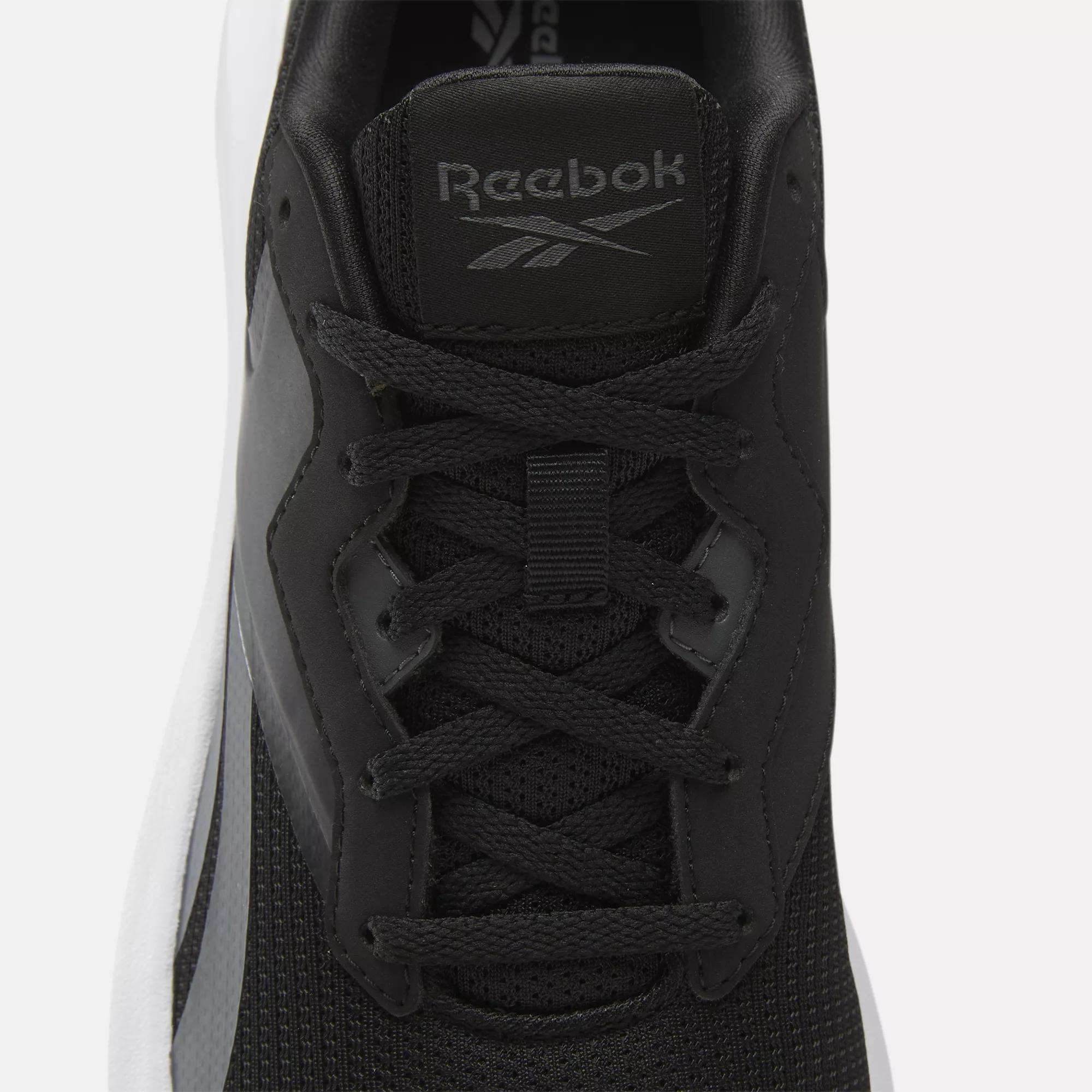 A close-up top view of Reebok Men's Energen Lux Running Shoes with black laces, dark gray accents, the Reebok logo on the tongue, and a white sole.