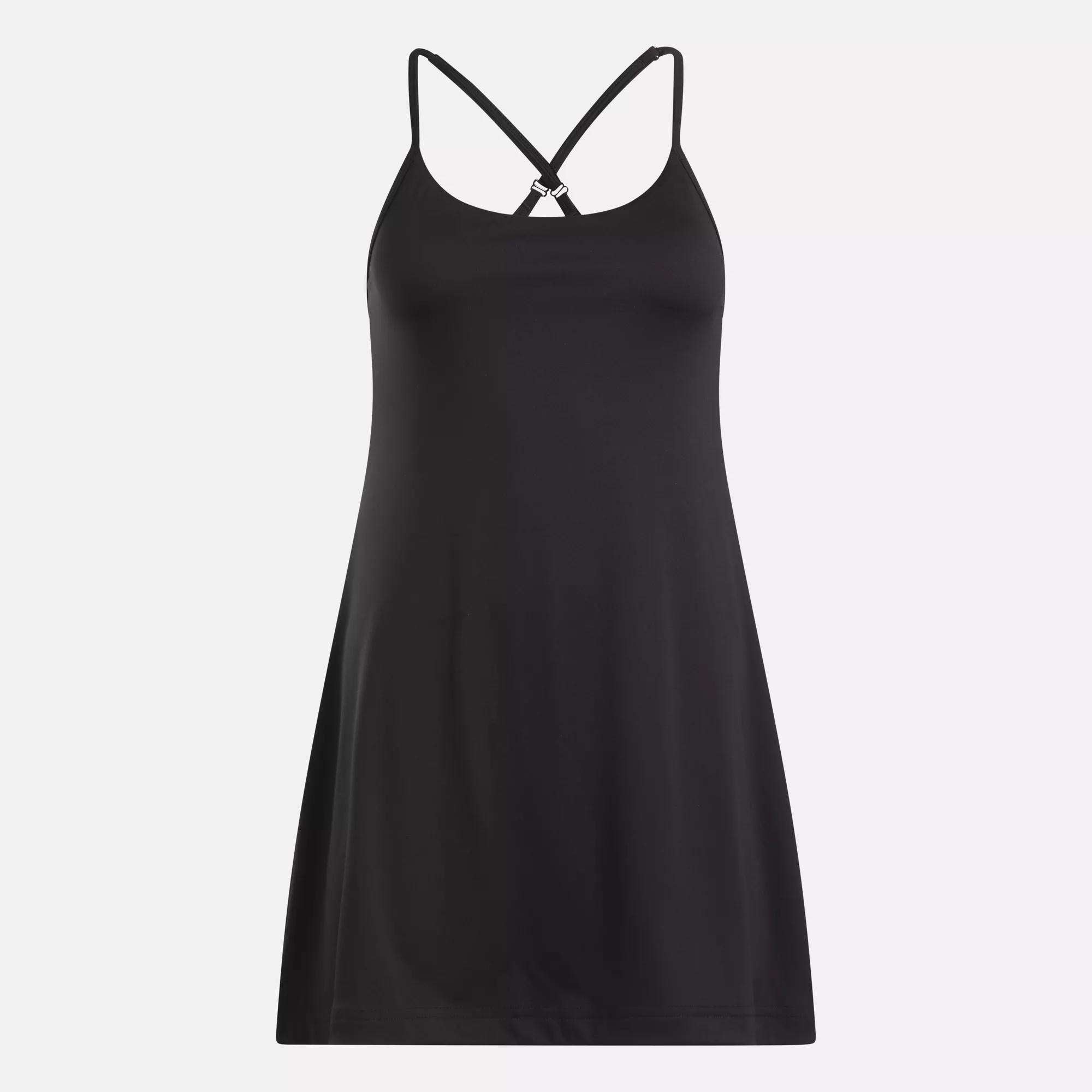 The Reebok Women's Lux Strappy Dress, in black stretch knit, features thin crisscross back straps and is shown against a plain light background.