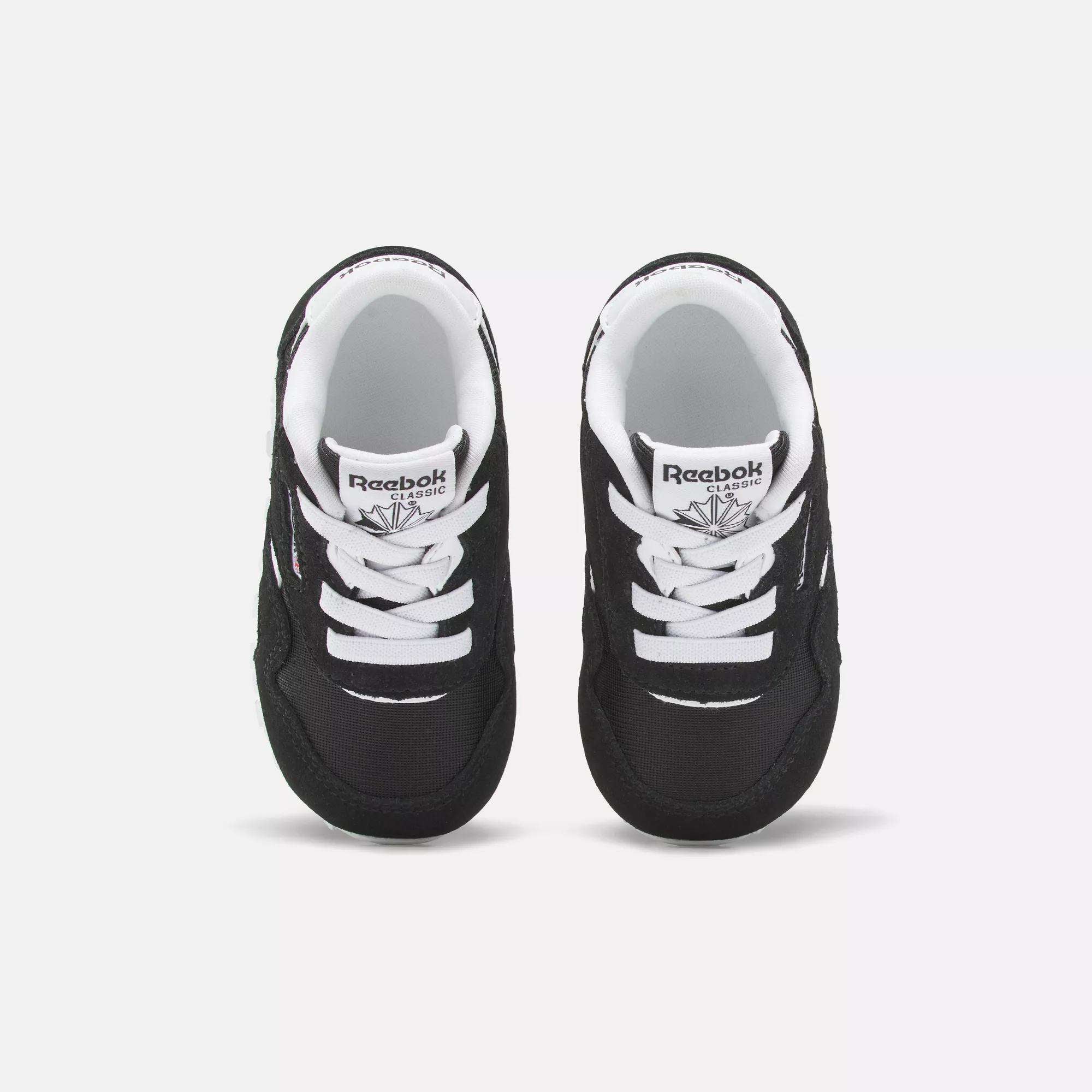 A pair of Reebok Kids' Classic Nylon Shoes for toddlers is shown from above on a white background. The shoes feature a black and white suede and nylon upper, white laces, and the Reebok logo on the tongue.