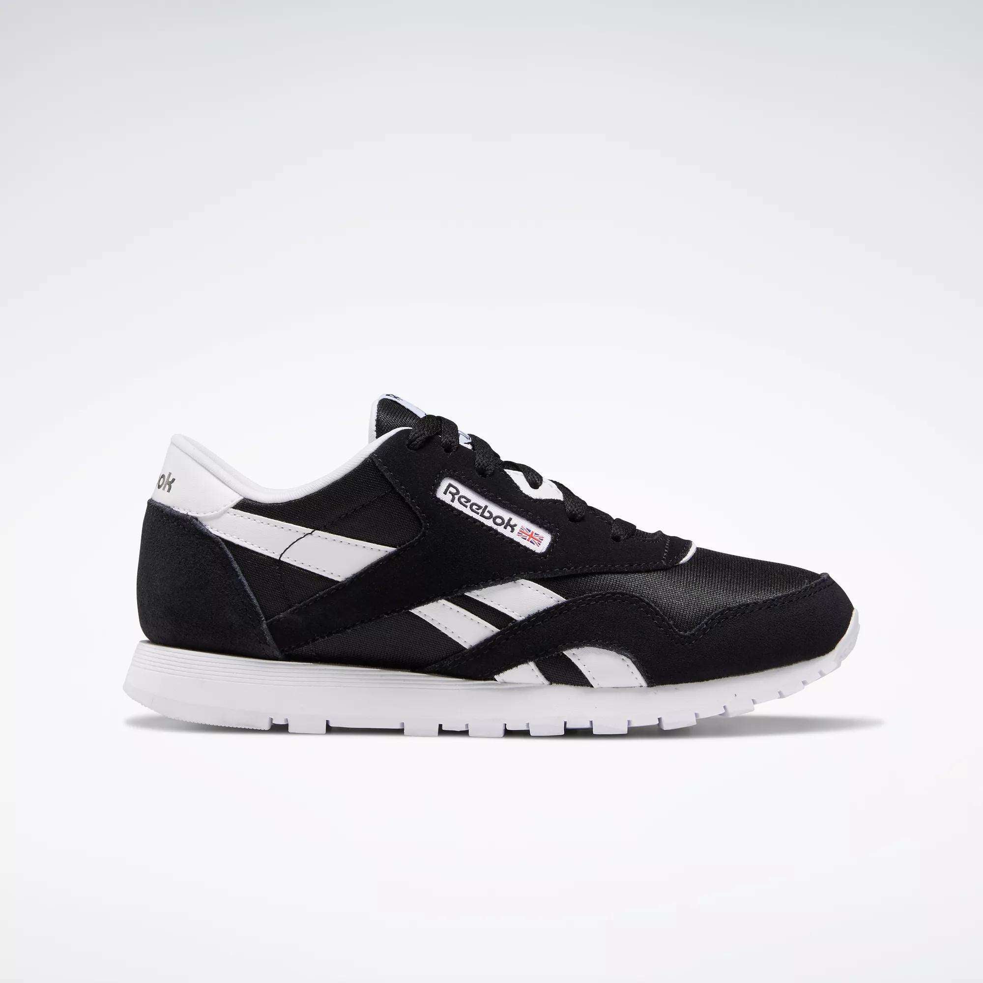 The Reebok Classic Nylon Shoes - Big Kids are displayed in black and white from a side angle on a white background, showcasing the iconic Reebok logo, white stripes, and sole—ideal for those who love minimalist style.