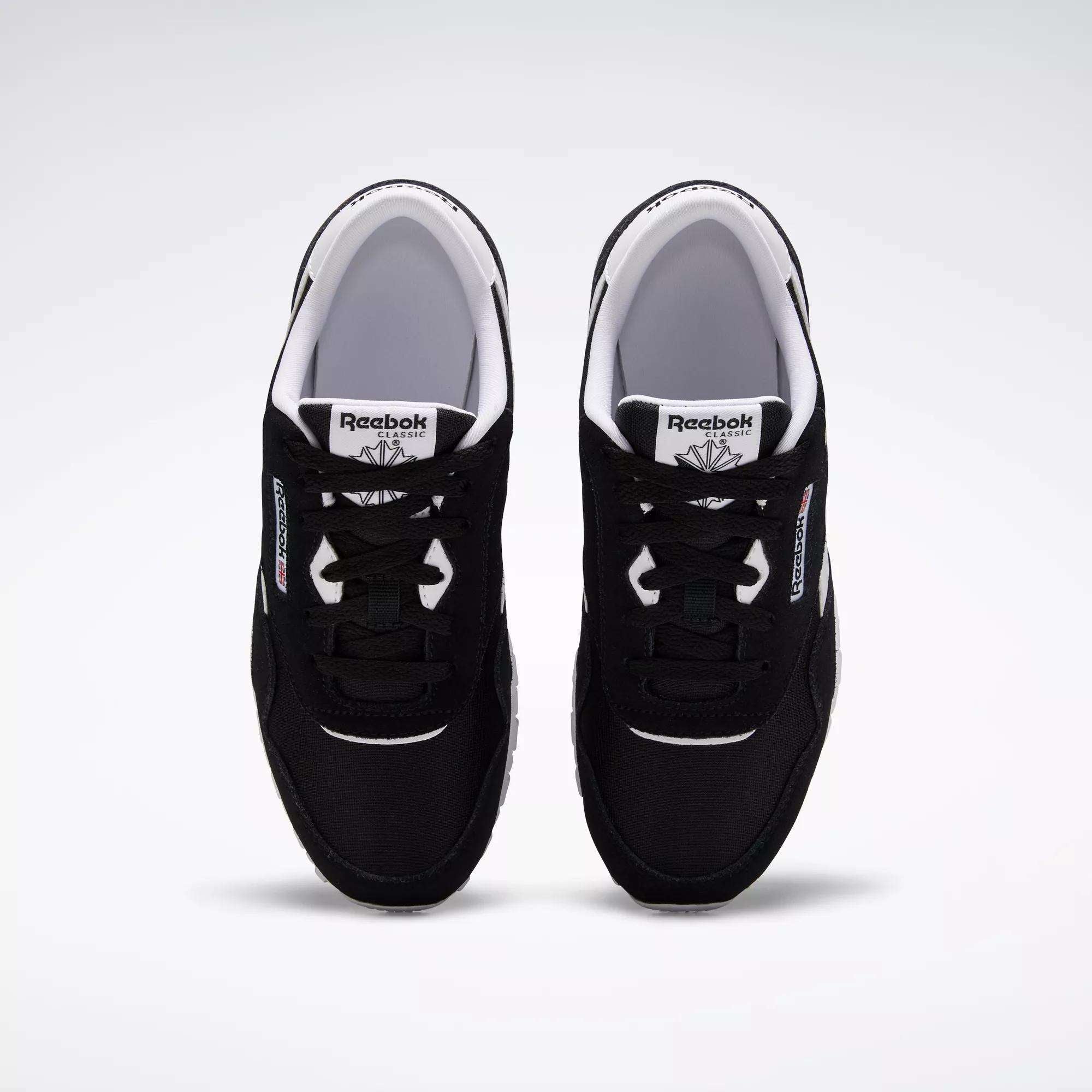 A pair of Reebok Classic Nylon Shoes - Big Kids in black with white soles and accents, inspired by '80s running styles, shown from above on a plain white background. The visible tongue and side logos highlight the Reebok brand.