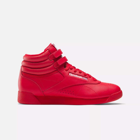 The Reebok Women's Freestyle Hi Shoes in Vector Red feature two Velcro straps, laces, and padded ankle support for fitness, shown in a side view on a plain white background.
