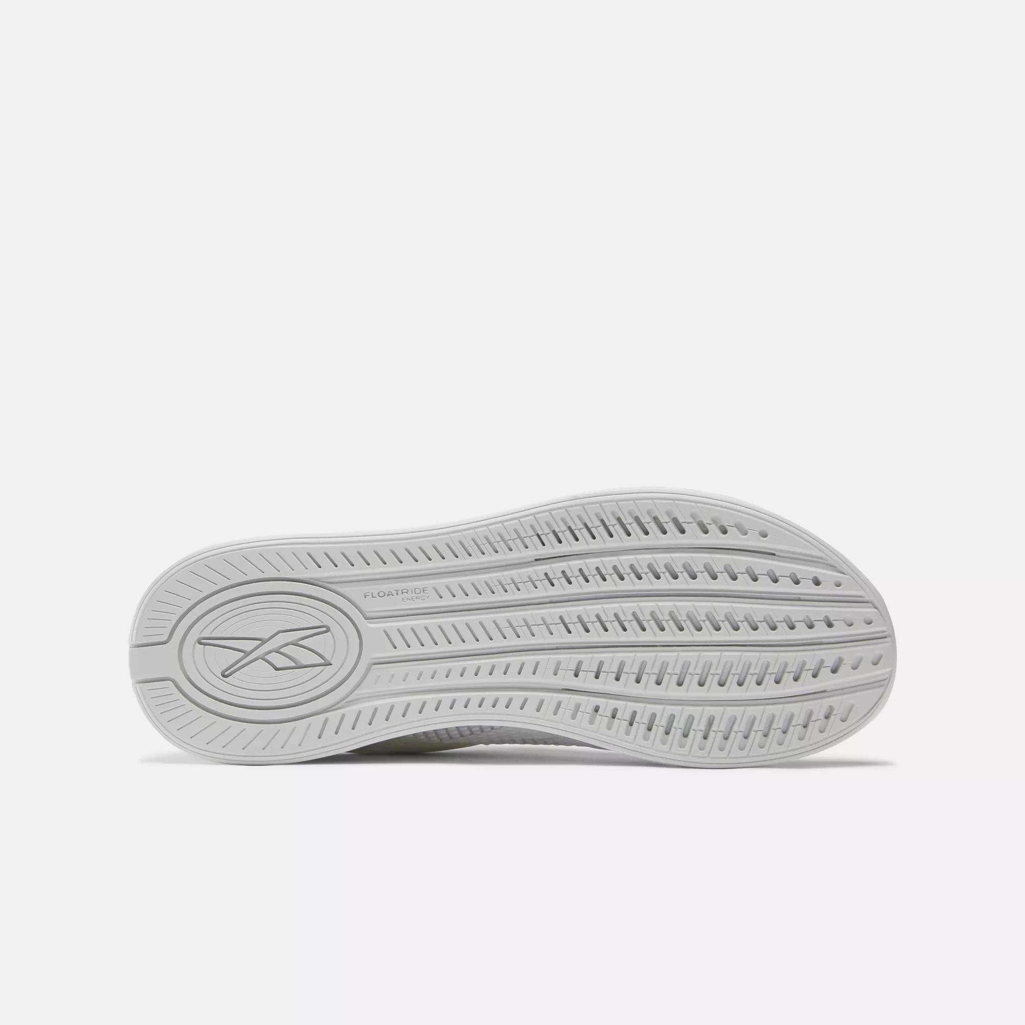 The image displays the sole of a light gray Reebok Nano X4 Women's Training Shoe, featuring a textured tread pattern and embossed Reebok logo near the heel, emphasizing its lightweight design.