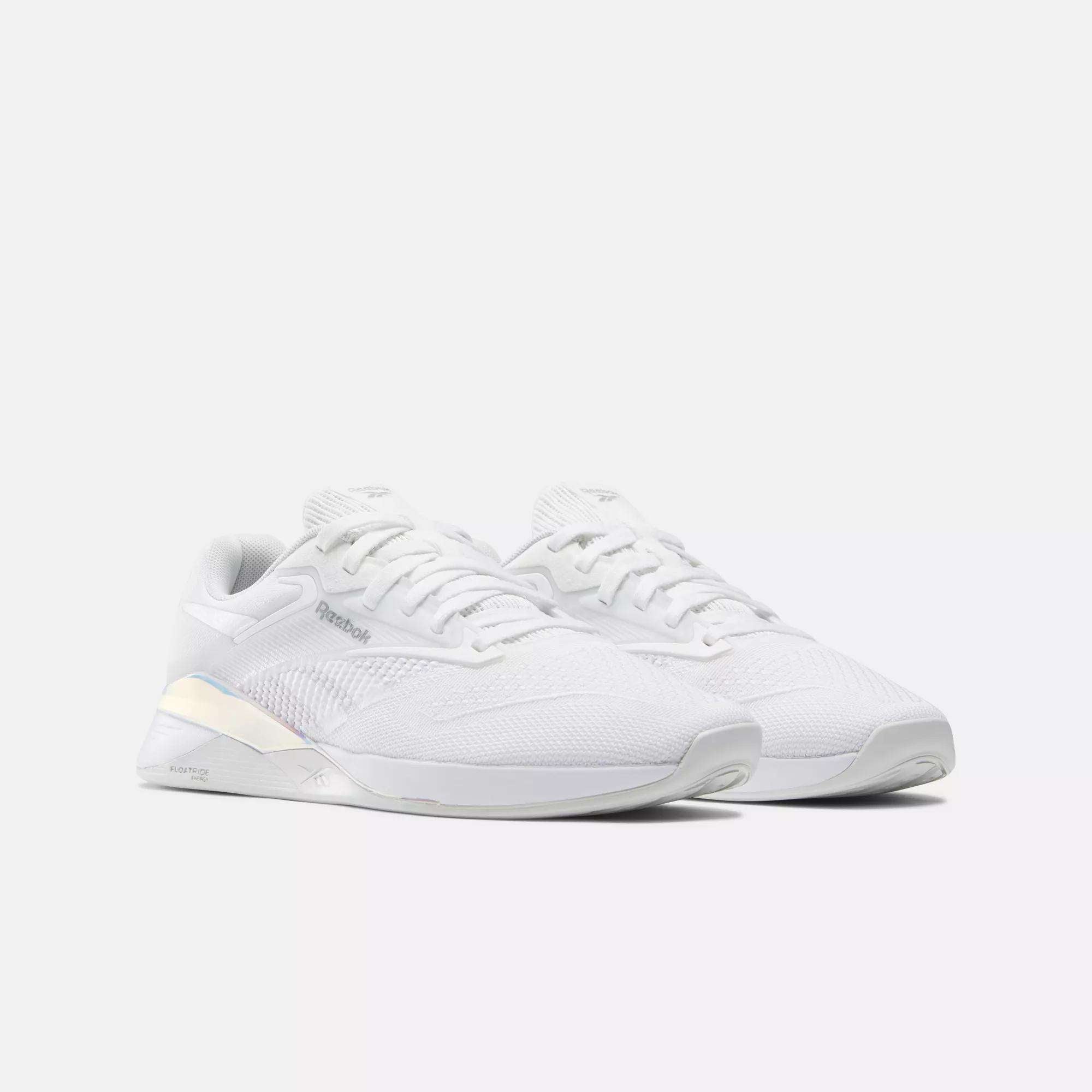 A pair of lightweight Reebok Nano X4 Women's Training Shoes in white with breathable mesh uppers, subtle branding, and iridescent heel accents, displayed against a plain light background.