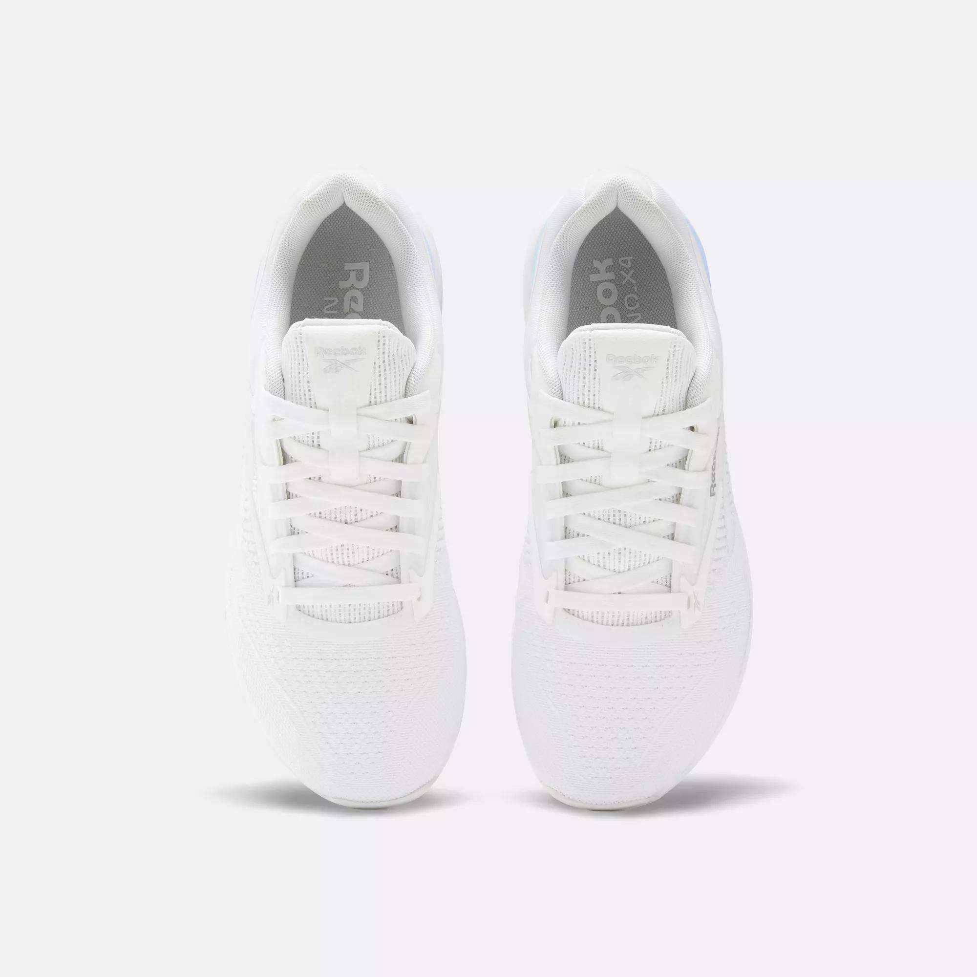 A pair of Reebok Nano X4 Women's Training Shoes in white, viewed from above, displays the laces, breathable mesh texture, and Reebok logo on the tongue against a plain light background.