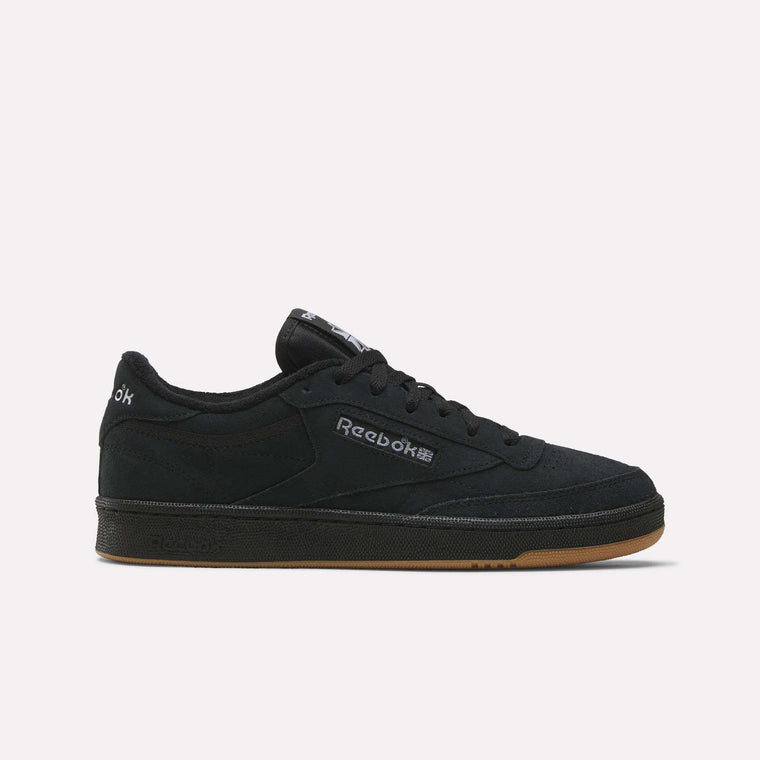 The Reebok Club C 85 Shoes feature a low-profile black suede upper, black sole, gum outsole, and a white Reebok logo on the side, shown against a plain light background.
