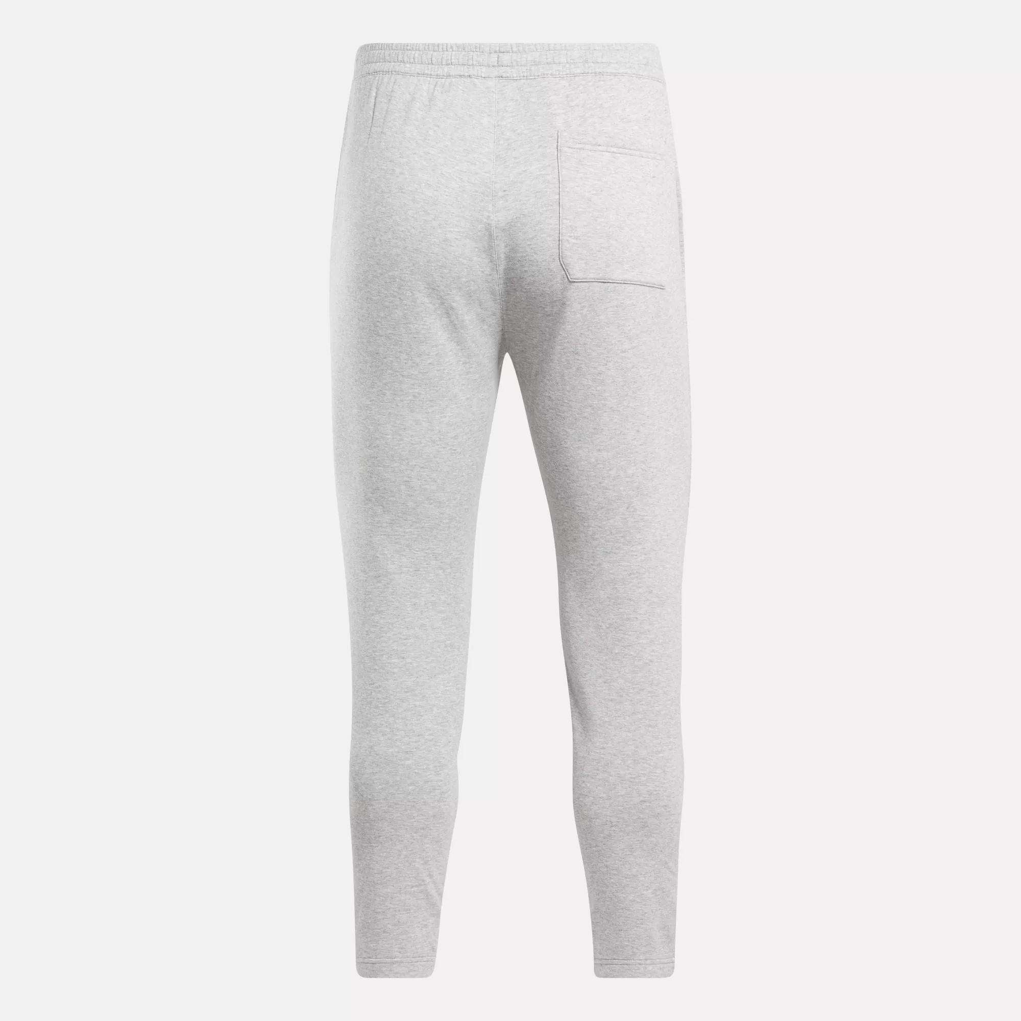 Back view of Reebok Men's Active Collective DreamBlend Pants in light gray, featuring an elastic waistband and a right-side patch pocket, made from soft DreamBlend fabric for comfort.