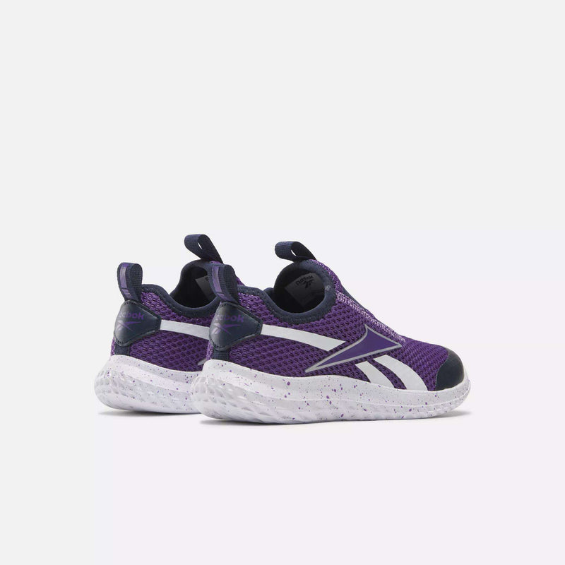 A pair of Reebok Kids' Rush Runner Slip-On Shoes for little kids in purple with white accents and a speckled sole, featuring lightweight cushioning, shown from the back and slightly to the side on a light plain background.
