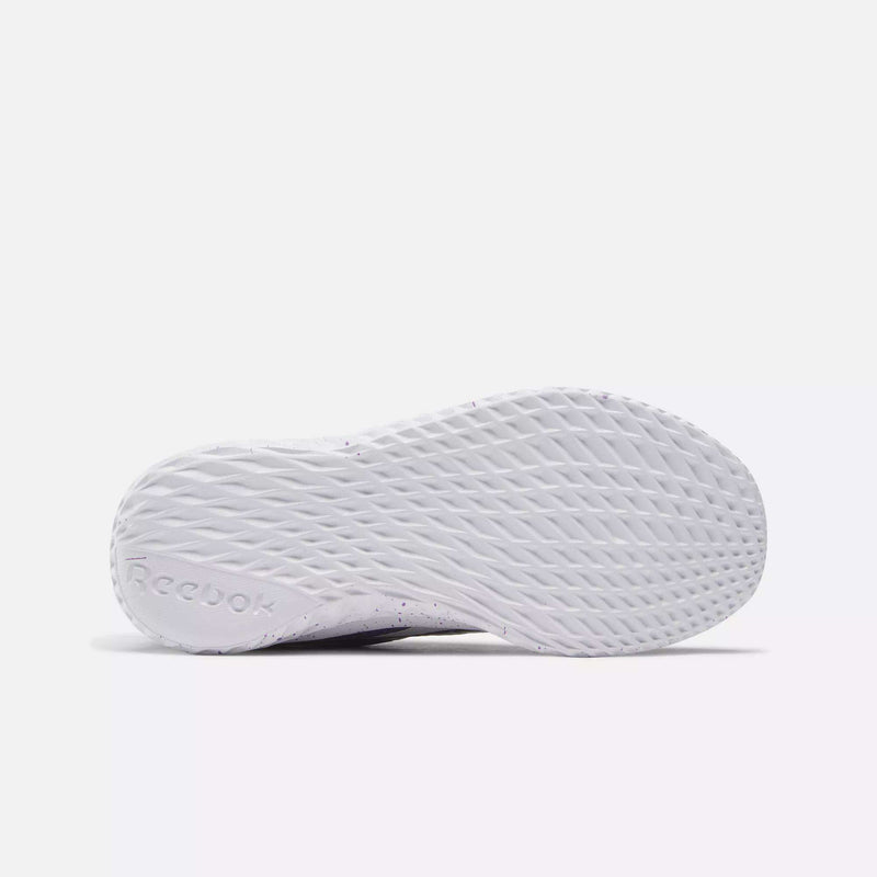 The image features the white textured sole of Reebok Kids' Rush Runner Slip-On Shoes for little kids, shown against a plain light background, with the Reebok logo visible near the heel.