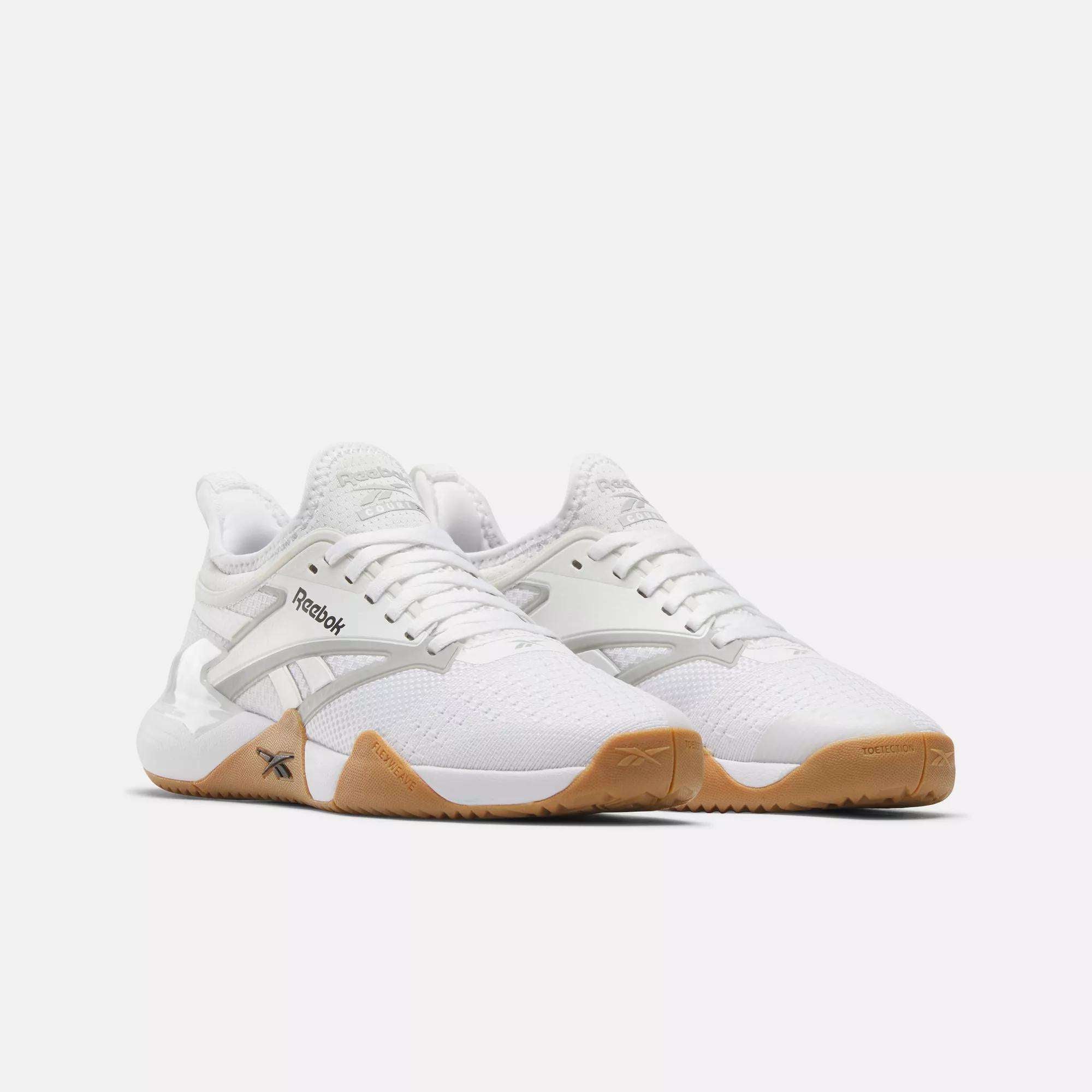 Women's Nano Court Training Shoes by Reebok, featuring gum rubber soles for multidirectional traction, mesh and synthetic uppers, plus Reebok logos on the sides and tongues, shown against a plain white background.