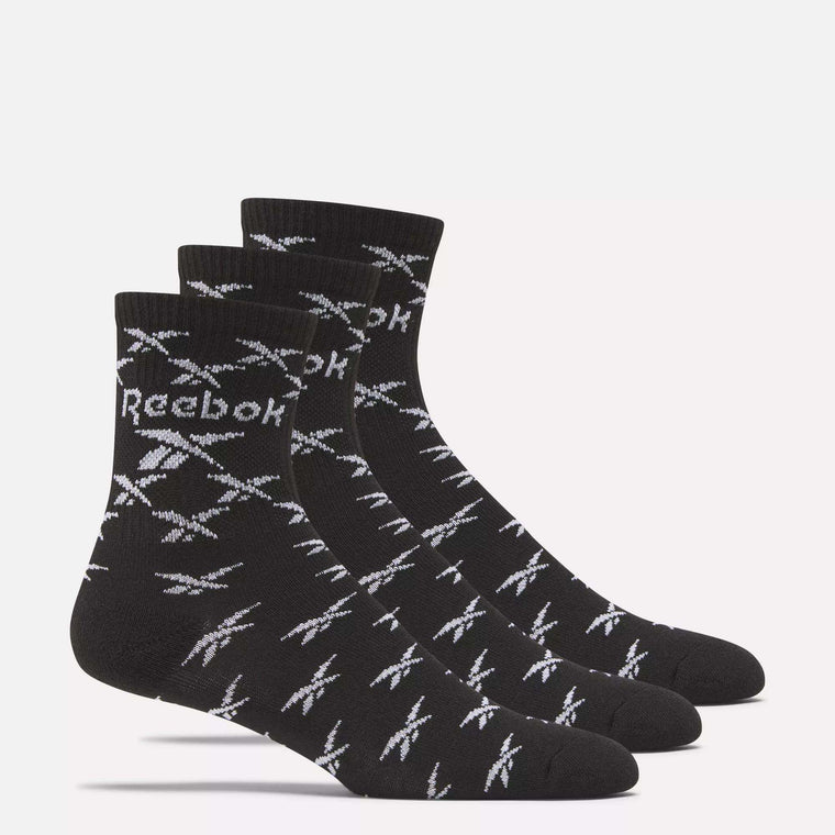Three pairs of Reebok Zone Cushion Mid Crew Socks are shown side by side, each black with white Reebok logos and patterns, on a plain light background.