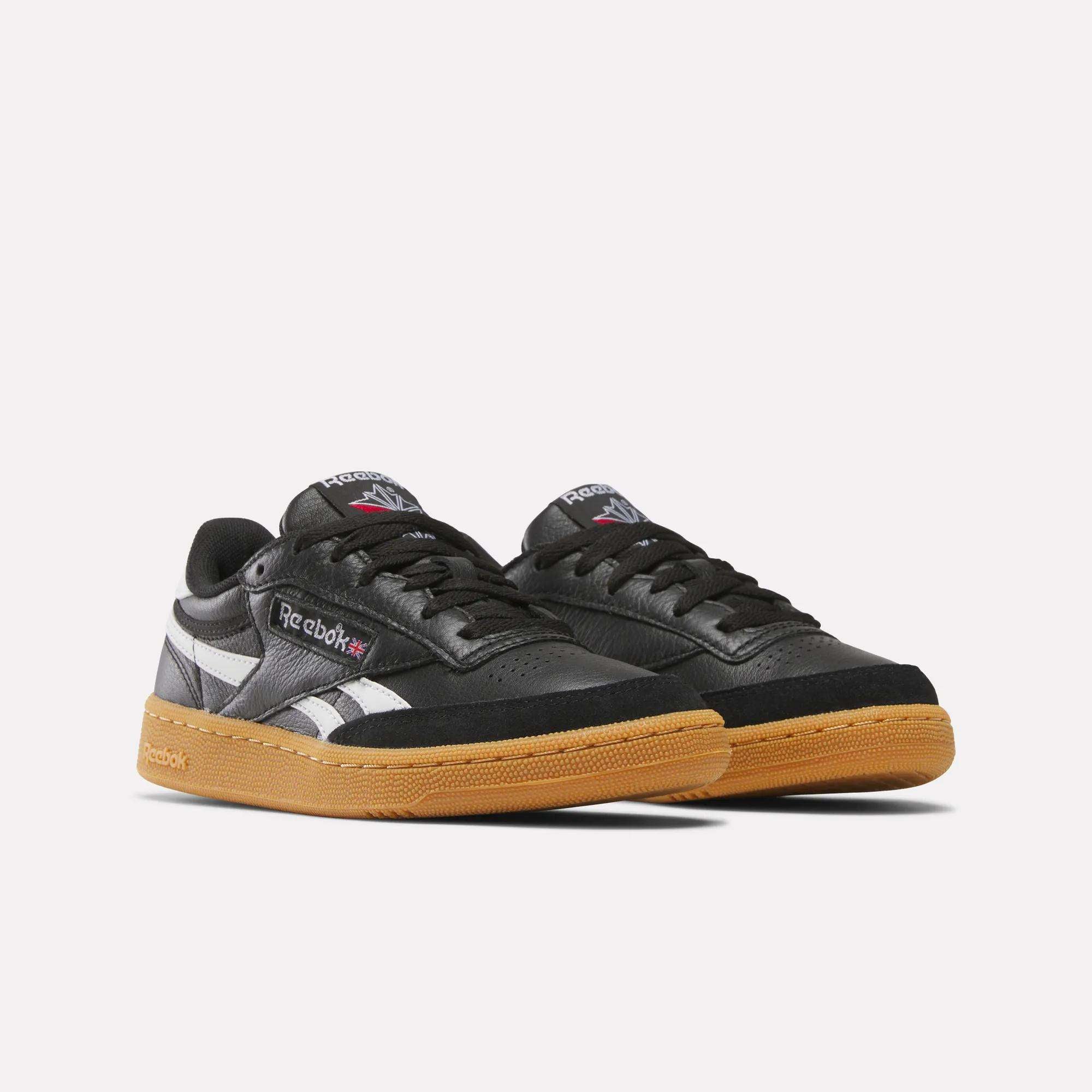A pair of Reebok Club C Revenge Vintage Shoes for men, black with white and silver accents, soft leather sneakers featuring black laces and gum soles, displayed on a plain white background.