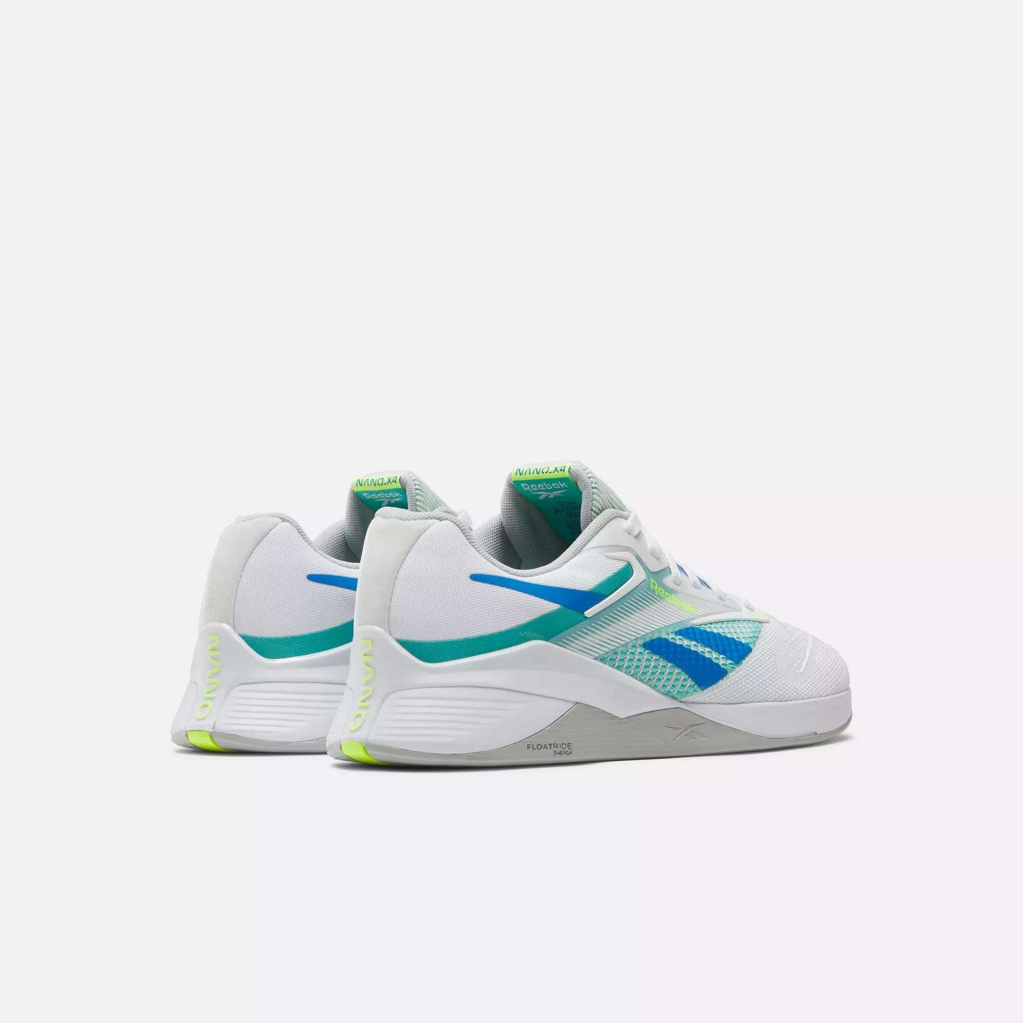 The Reebok Nano X4 Training Shoes are white, lightweight sneakers with blue and green accents, breathable mesh panels, and chunky soles. Both shoes are side by side, angled away on a plain white background.