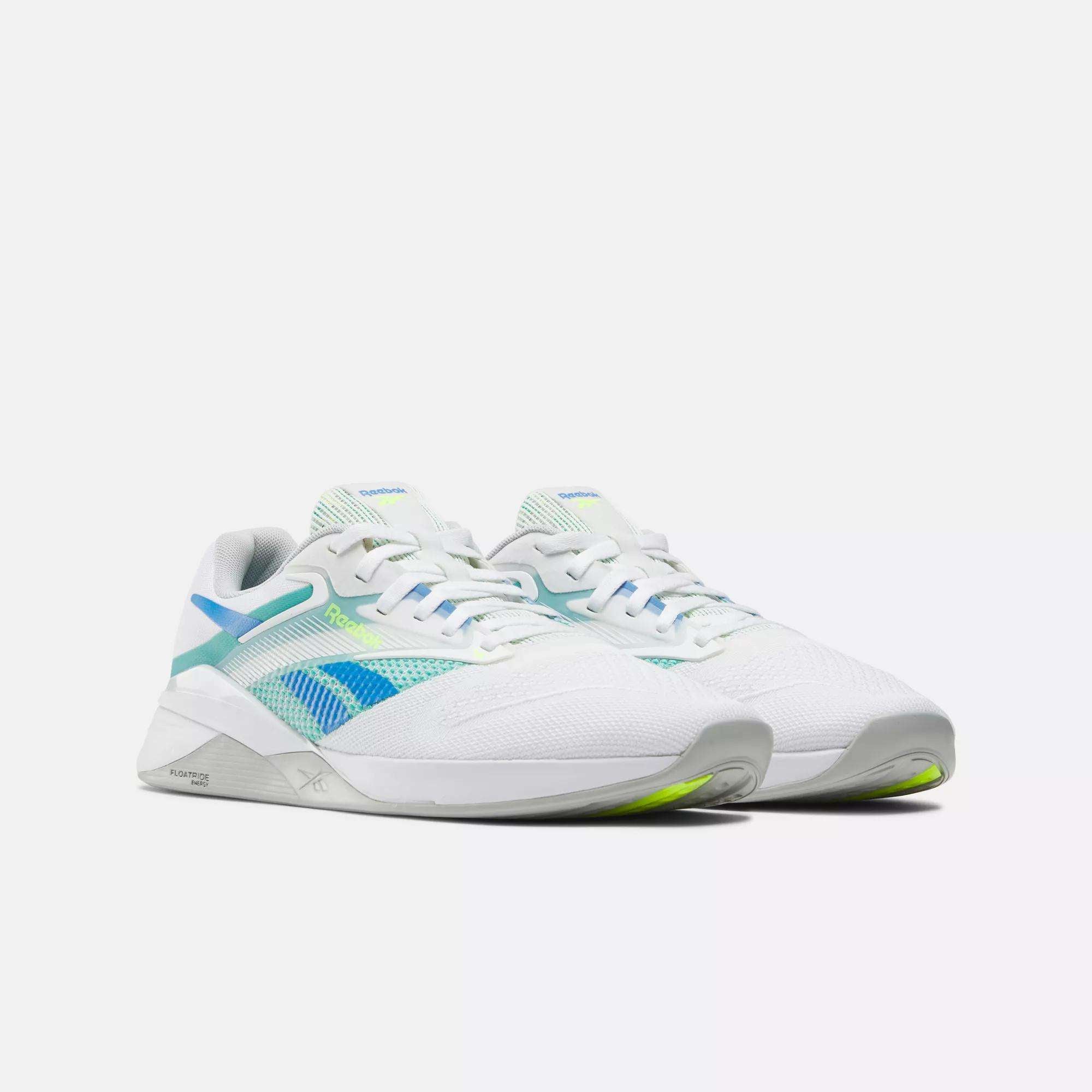 Reebok Nano X4 Training Shoes in white with light blue and green accents, featuring mesh panels for breathability and a low-cut, lightweight design, shown on a plain white background.