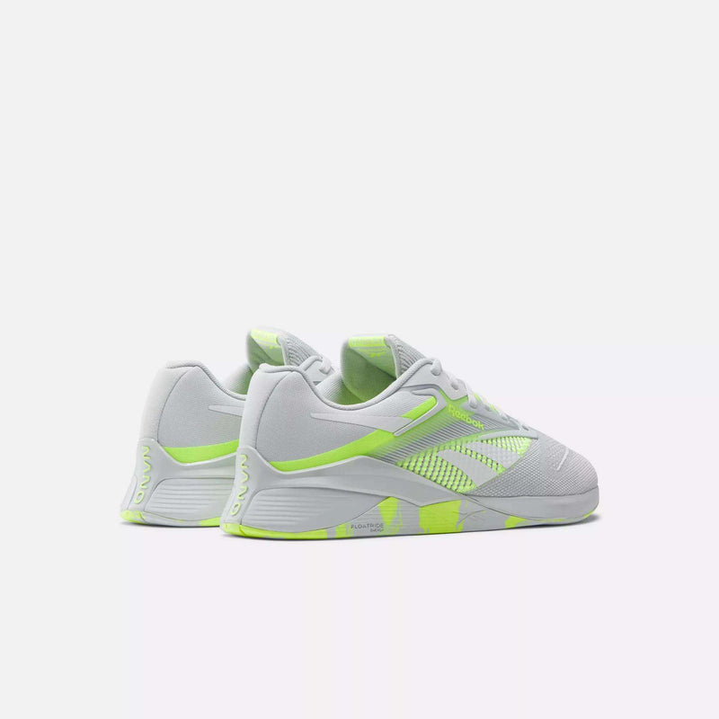 The Reebok Nano X4 Training Shoes, shown in white and neon green on a light background, are angled to display both the side and back. These sneakers feature breathable mesh uppers with synthetic detailing.