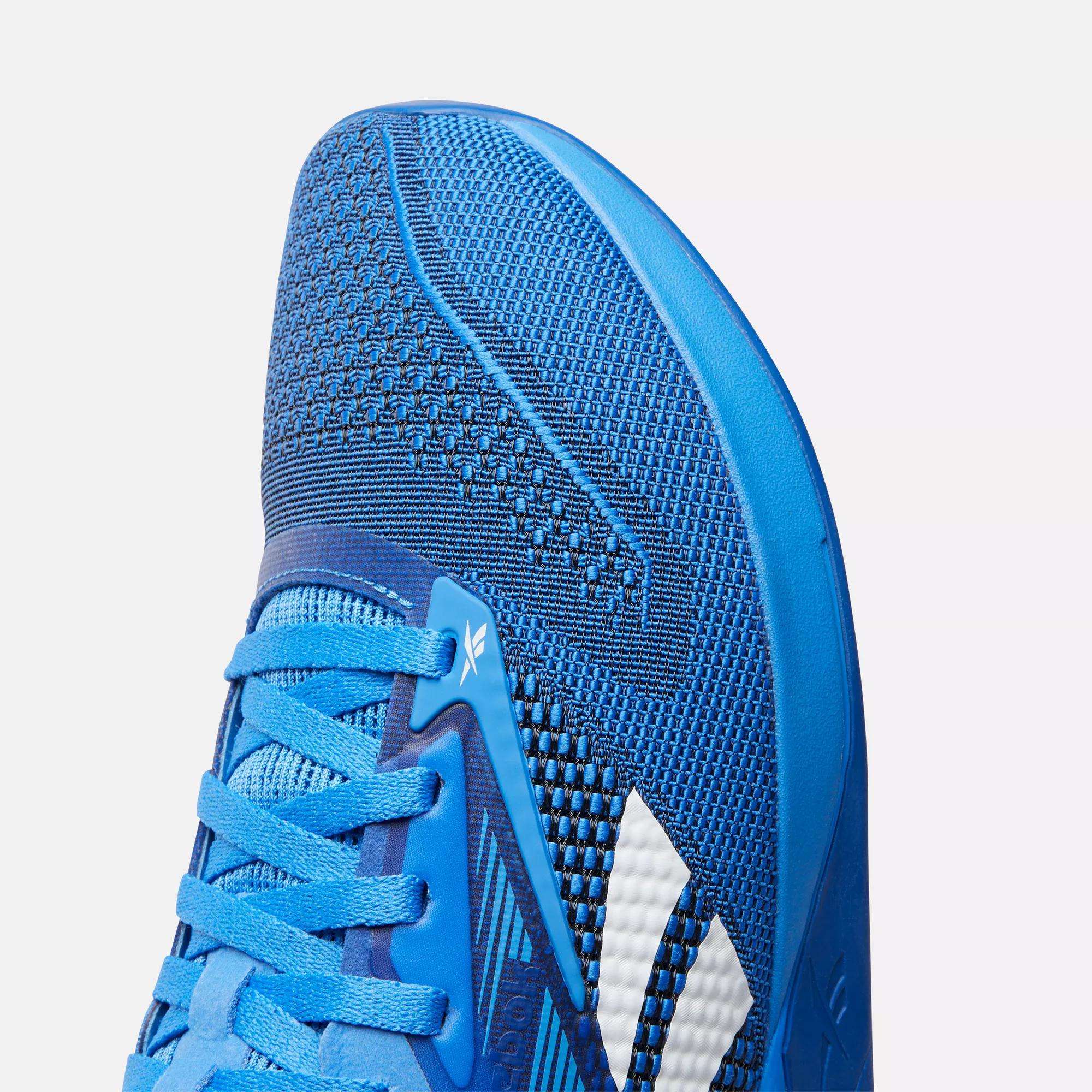 Close-up of the toe and side of the Reebok Nano X4 Training Shoes, featuring blue breathable mesh fabric, blue laces, and white accent stripes.