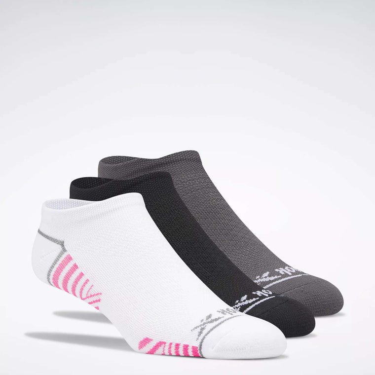 Three pairs of Reebok Women's Zoned Cushion No-Show Socks are shown overlapping on a white background: one white with pink and gray accents, one solid black, and one solid gray.