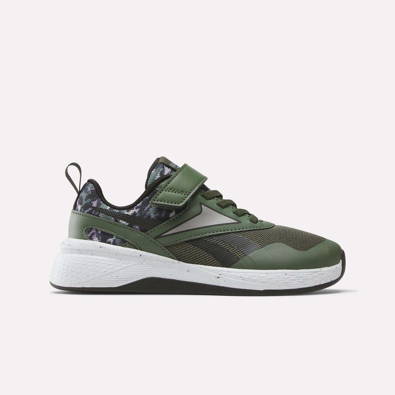 The Reebok Nano Play Stretch Lace And Top Strap Shoes for little kids feature a green and black design with a white sole, black laces, Velcro strap, and a camouflage heel/collar, shown against a plain light background.