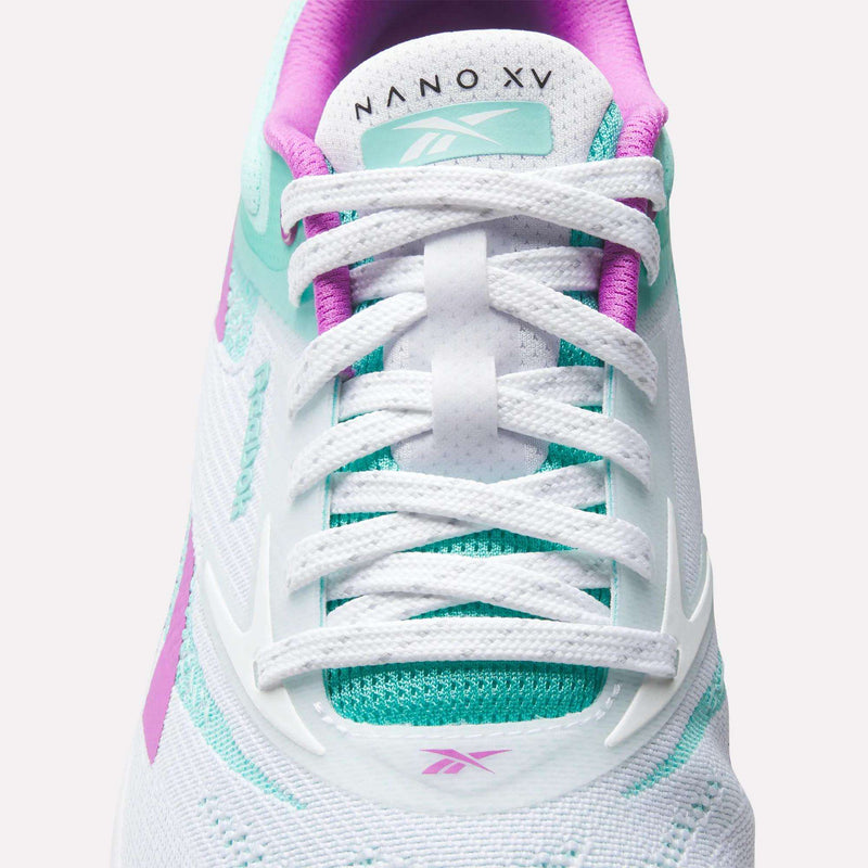 Close-up of a white Reebok Nano X5 Training Shoe with teal and purple accents, white laces, and "NANO X5" text on the tongue. Features mesh and synthetic details for men's training support.