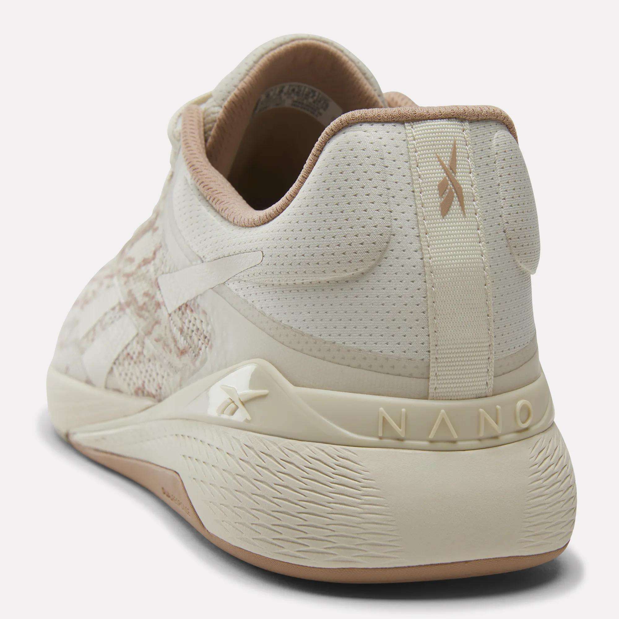 The Reebok Nano X5 Training Shoes for men in beige and cream feature a textured sole, breathable mesh upper, and branding on the heel and side; shown from back and side views, perfect for comfortable runs.