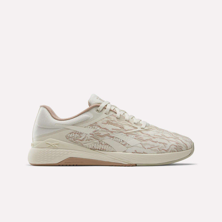 The Reebok Nano X5 Training Shoes feature a beige and light pink design with a textured pattern, lace-up front, and slightly elevated sole. These comfortable athletic sneakers are perfect for running or training. Shown on a plain white background.