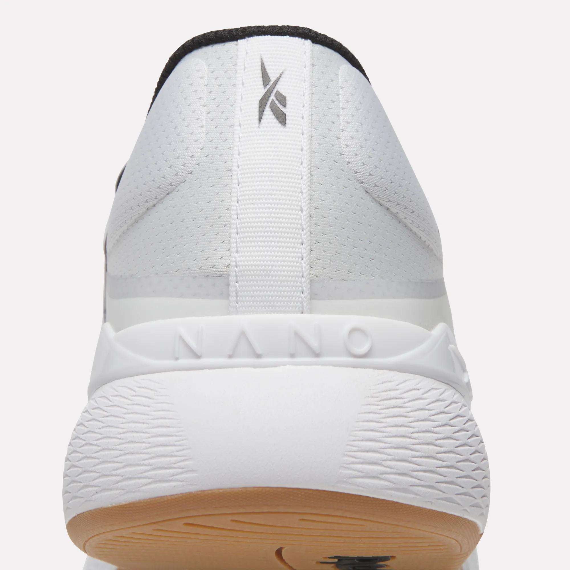 Close-up of the back of a white Reebok Nano X5 Training Shoe showing a textured tan outsole, NANO embossed on the heel, and a small gray logo on the upper heel tab. The visible tread pattern offers comfort for running and training.