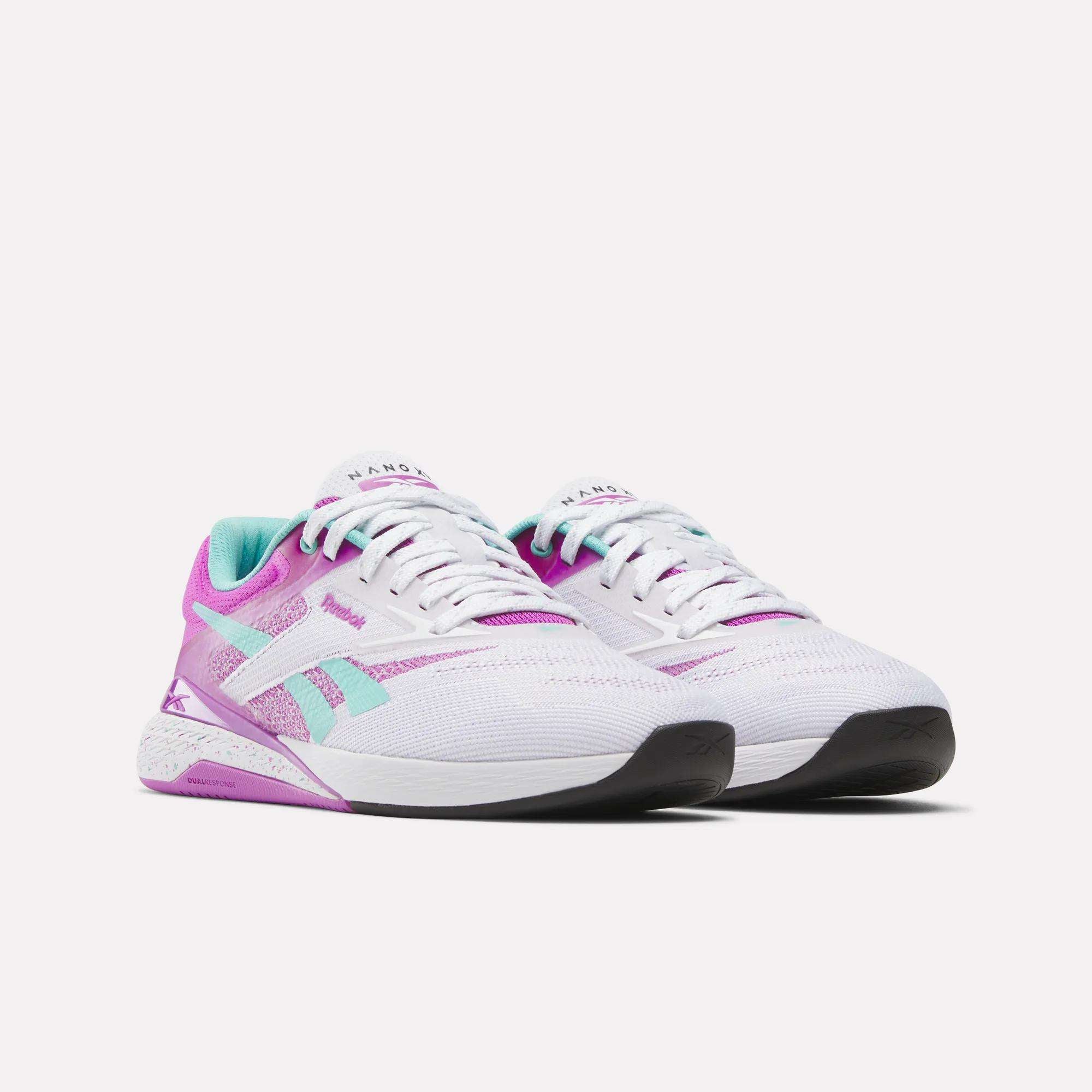 The Reebok Women's Nano X5 Training Shoes feature white mesh uppers with pink, purple, and teal accents, black soles, and are shown side by side on a plain white background.