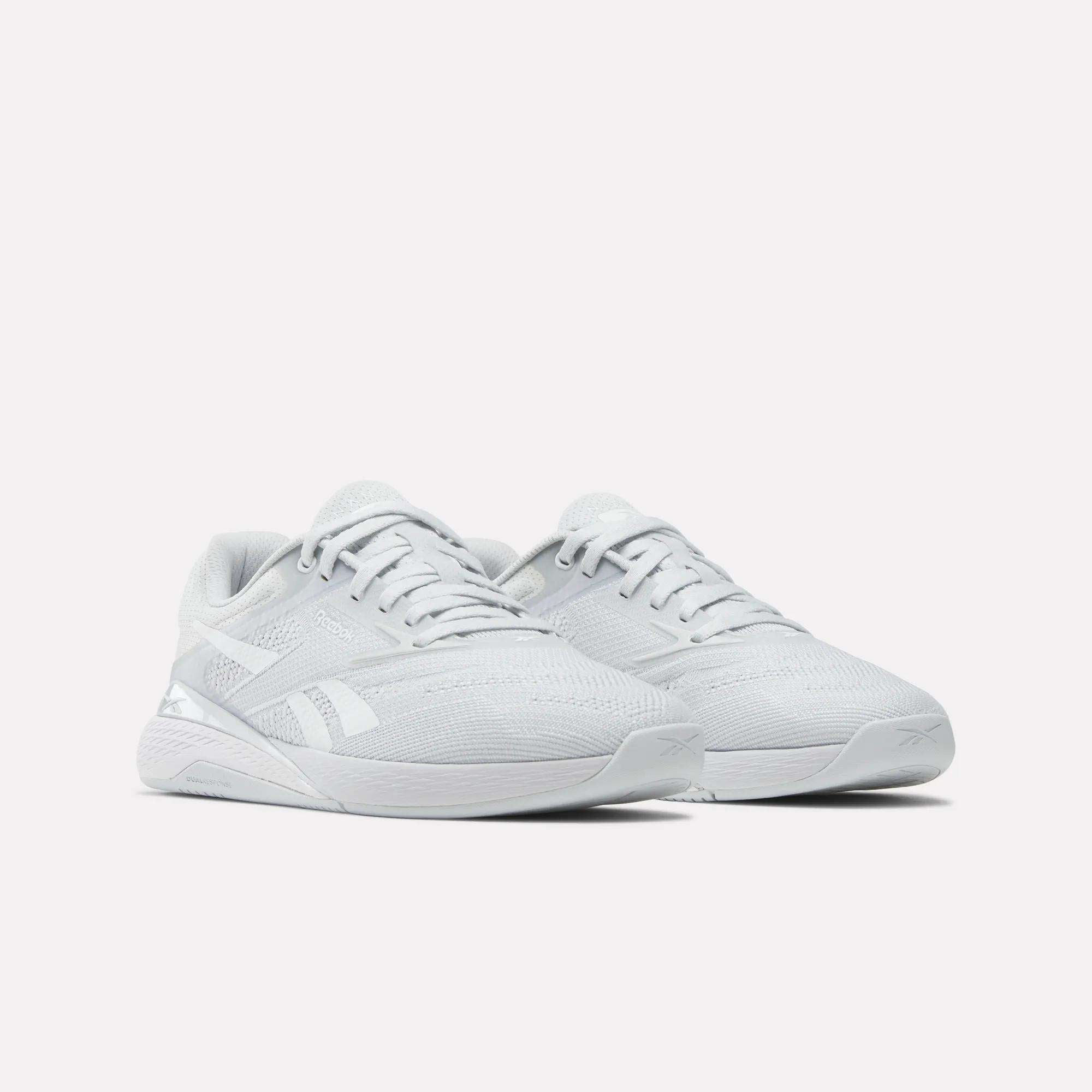 The Reebok Women's Nano X5 Training Shoes feature comfortable white mesh uppers, rubber soles, and the Reebok logo on the sides—perfect for women's training—shown against a plain white background.