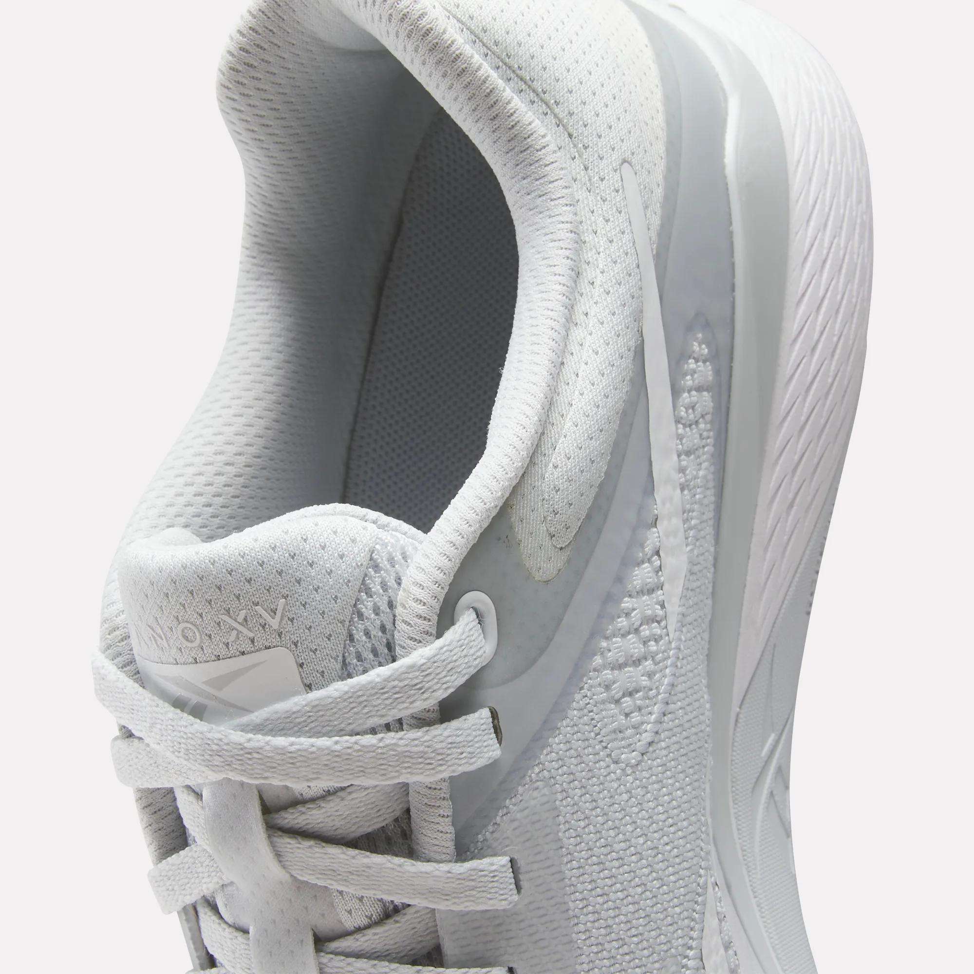 Close-up of the Reebok Women's Nano X5 Training Shoes in white, highlighting the laces, tongue, and padded collar. These comfortable trainers feature mesh and textured fabric details with a white rubber sole.