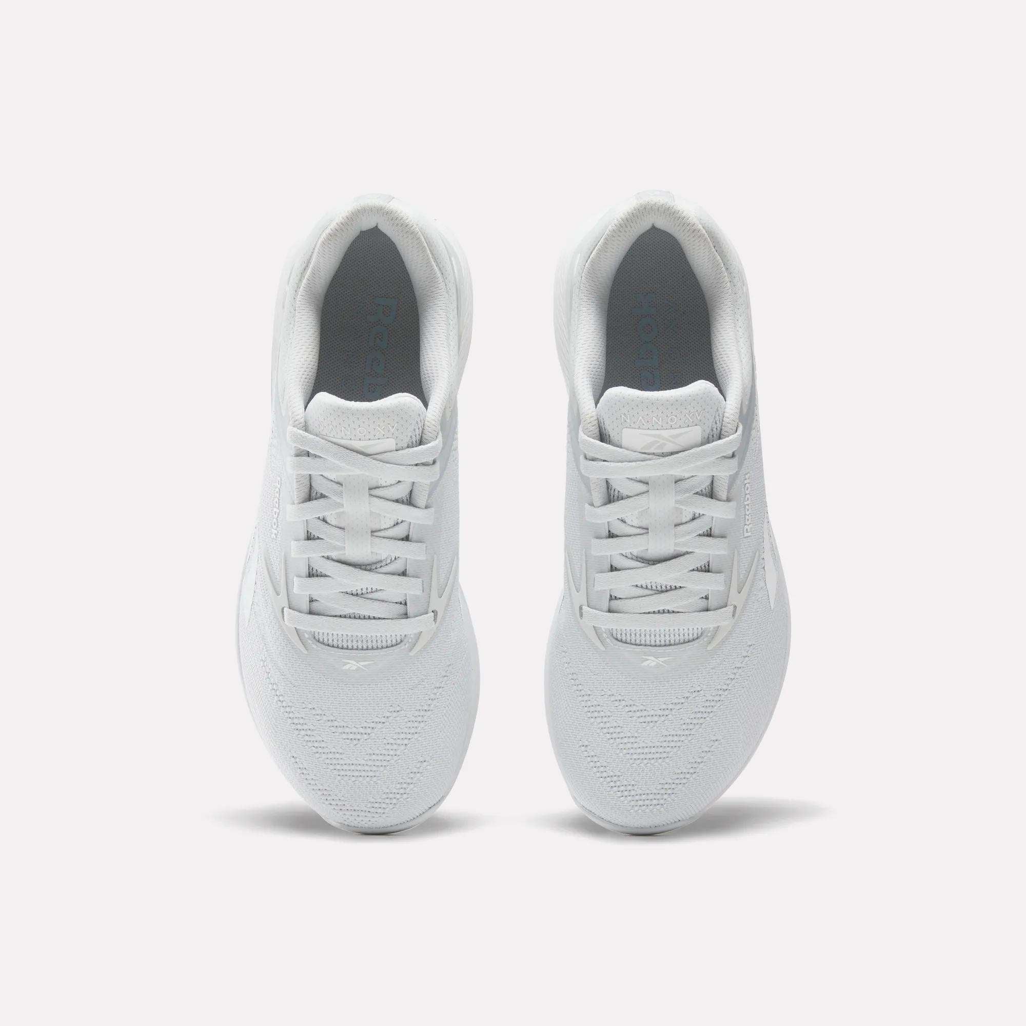 Two Reebok Women's Nano X5 Training Shoes are shown from above on a white background, highlighting their laces, breathable mesh texture, and the Reebok side logo.