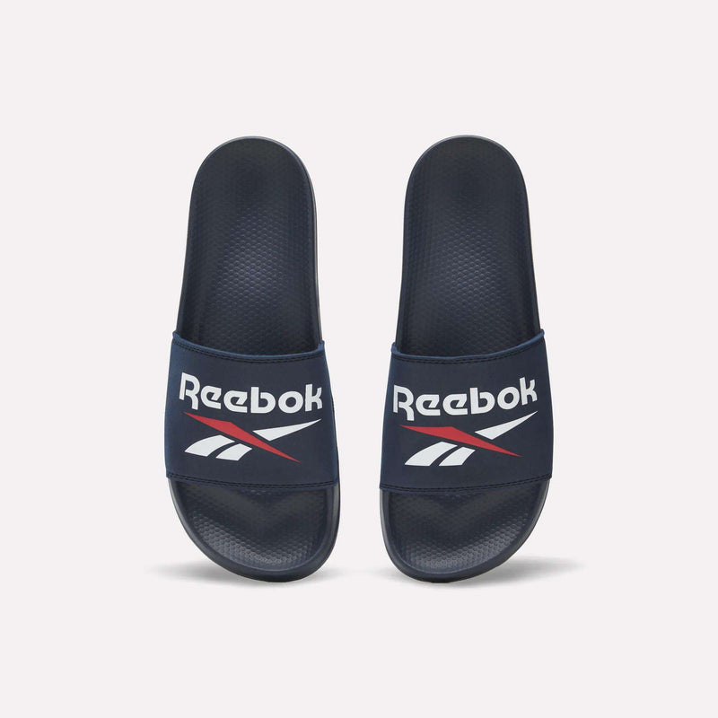 The Reebok RBK Fulgere Swim Slides in navy blue feature a white Reebok logo and red-accented top straps, shown side by side on a white background. Enjoy easy slip-on comfort for poolside or casual wear.