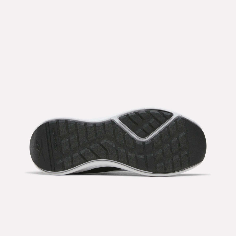 The image displays the black rubber sole of the Reebok Energen Running Shoes for little kids, viewed from below. Designed for durability and support, the sole features textured, rectangular grip patterns and a white outer edge to provide optimal traction—making them ideal running shoes for kids.