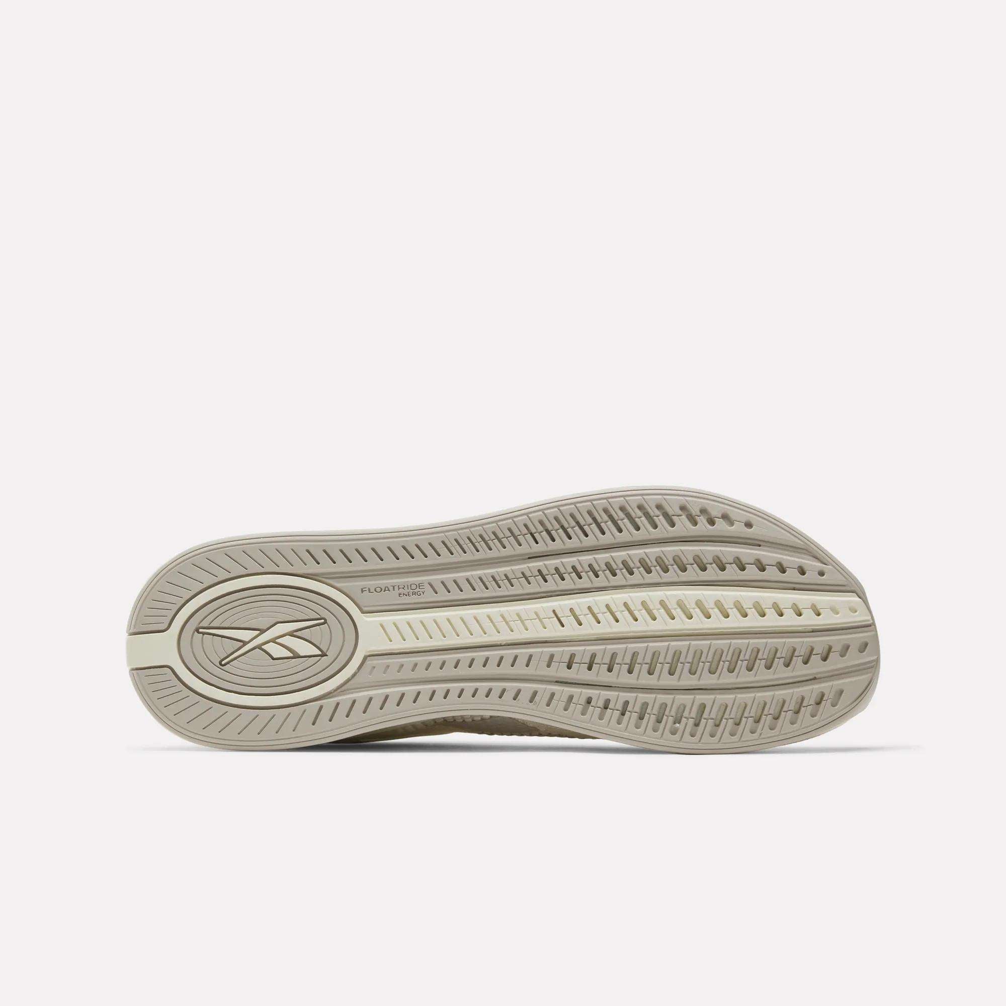 The image displays the light beige outsole of the Reebok Nano X4 Training Shoes, showing the Reebok logo and a textured tread with grooves for grip. The shoe’s lightweight design stands out against a plain white background.