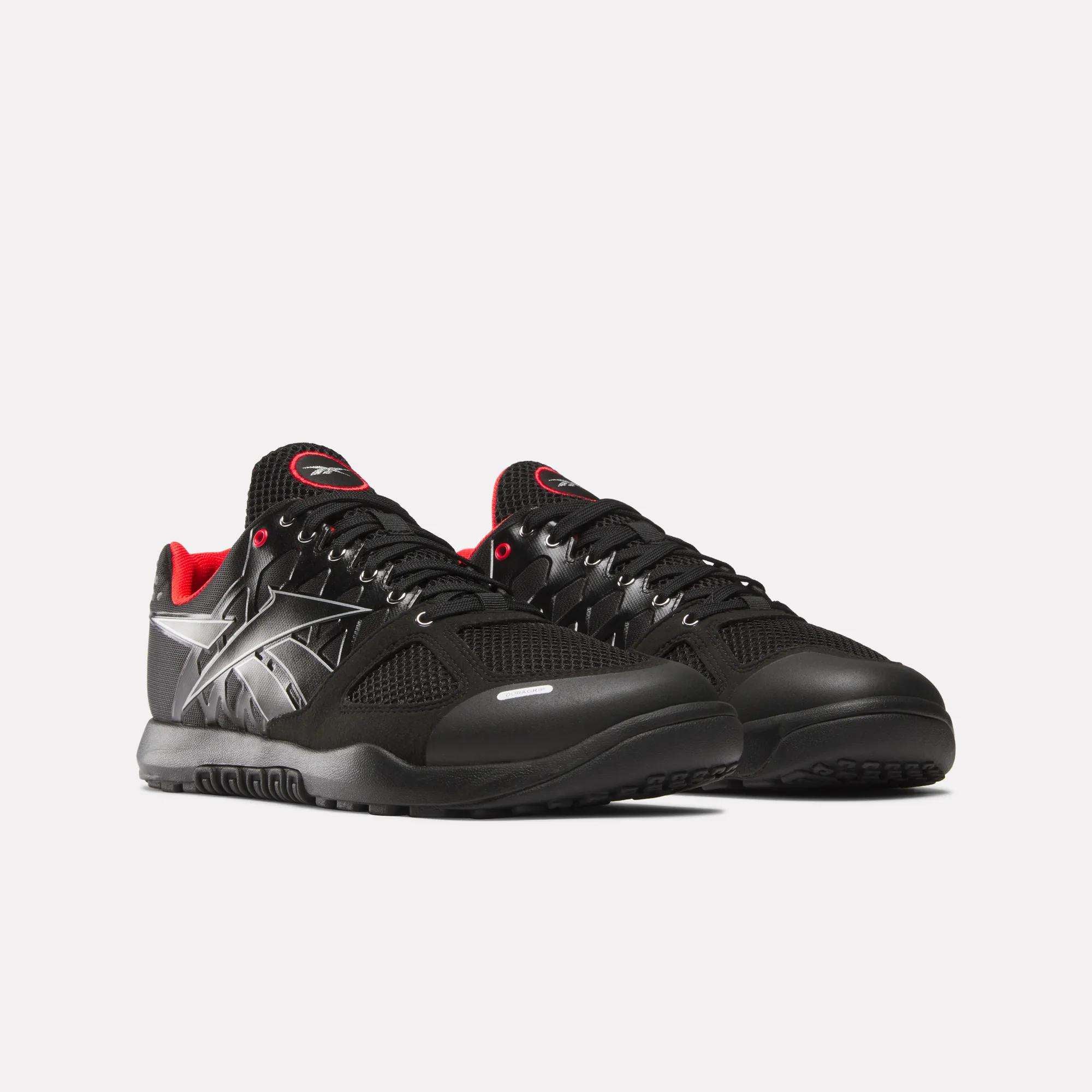 The Men's Nano 2.0 Training Shoes by Reebok are black with red inner lining, black laces, and silver side detailing, designed for functional fitness and shown on a plain white background.