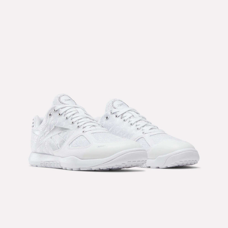 A pair of Reebok Women's Nano 2.0 Training Shoes in white, featuring translucent mesh panels, textured details, and white rubber soles for functional fitness, displayed on a plain light background.