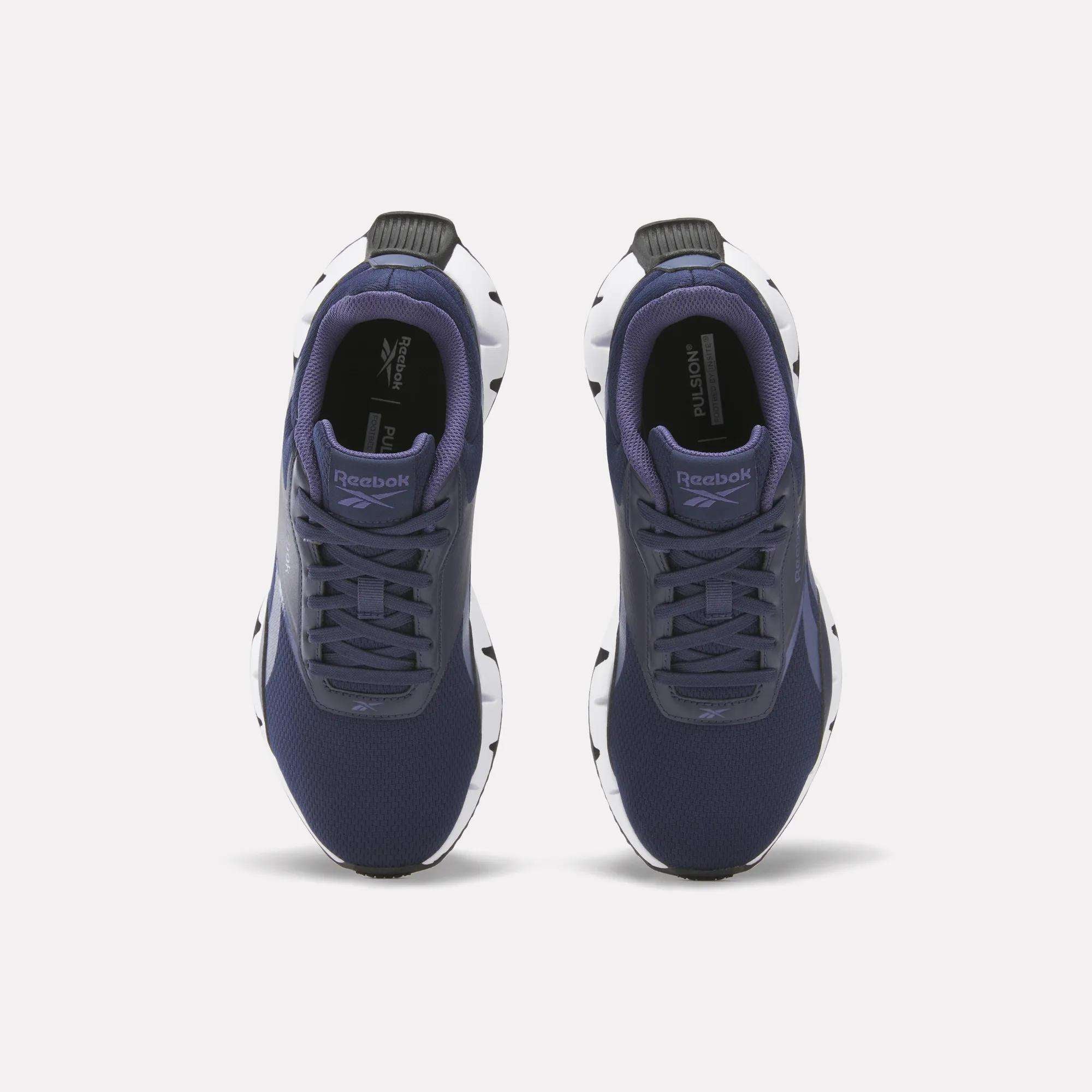 A pair of Reebok Women's Zig Dynamica STR Shoes in navy blue with white and black soles, displayed from above on a plain white background.
