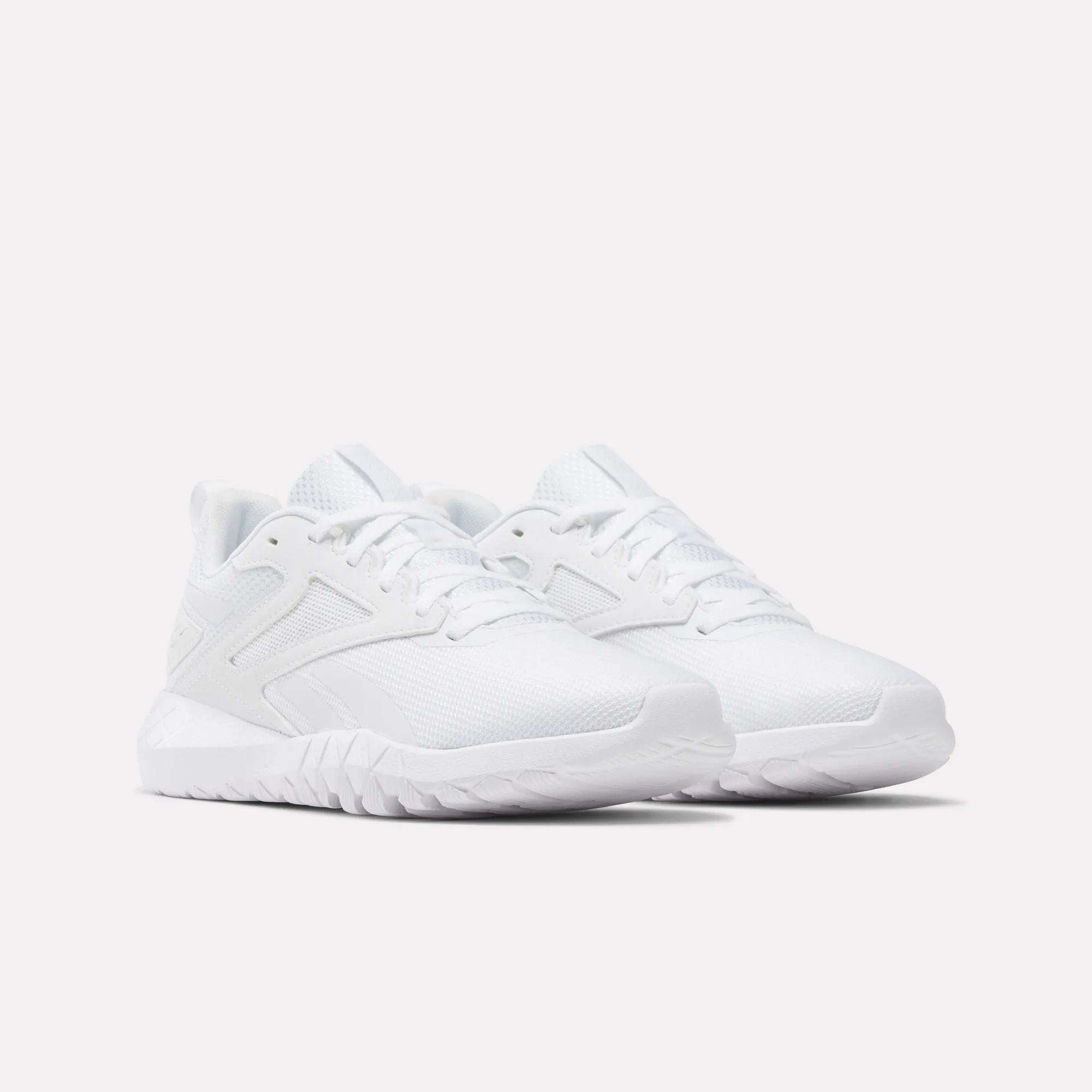 A pair of Reebok Women's Flexagon Energy 4 Training Shoes in all-white, with mesh uppers, textured soles, lace-up fronts, and responsive cushioning for comfort, displayed side by side on a plain white background.