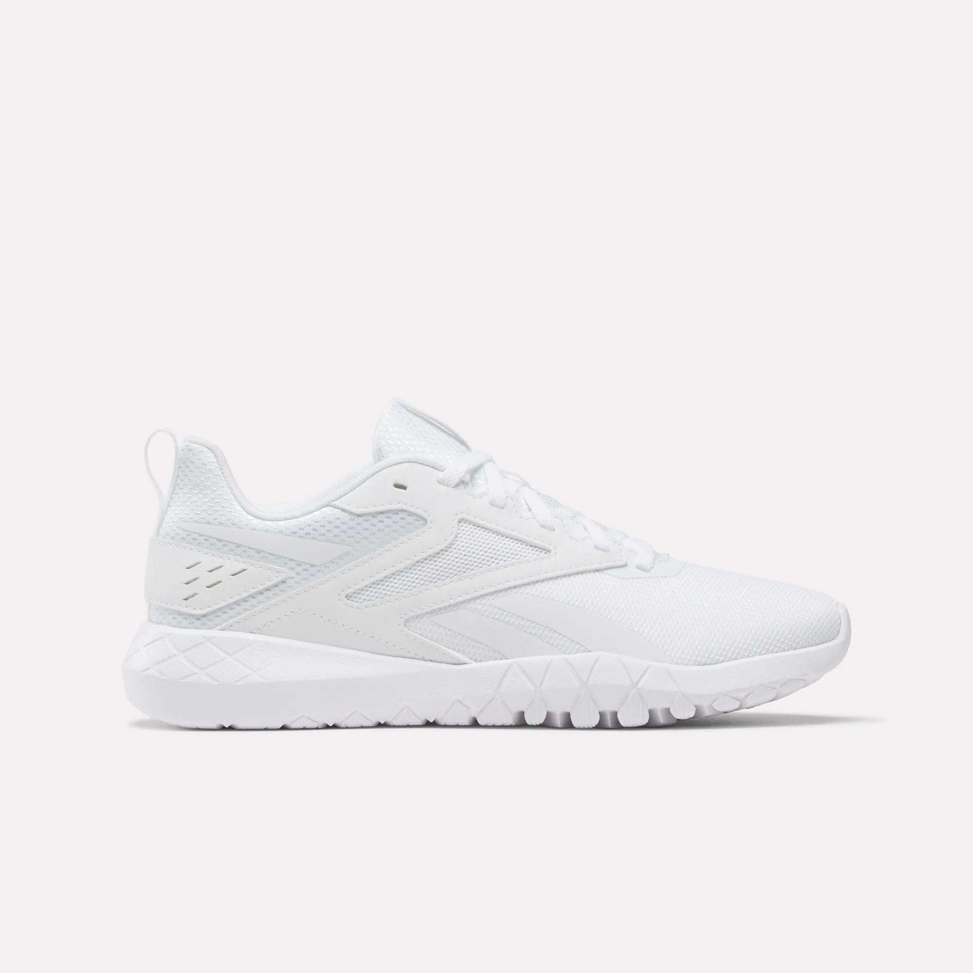 The Reebok Women's Flexagon Energy 4 Training Shoes feature a white mesh upper, lace-up closure, geometric side details, and a textured rubber sole for lightweight comfort and responsive cushioning. Shown from the side on a plain white background.