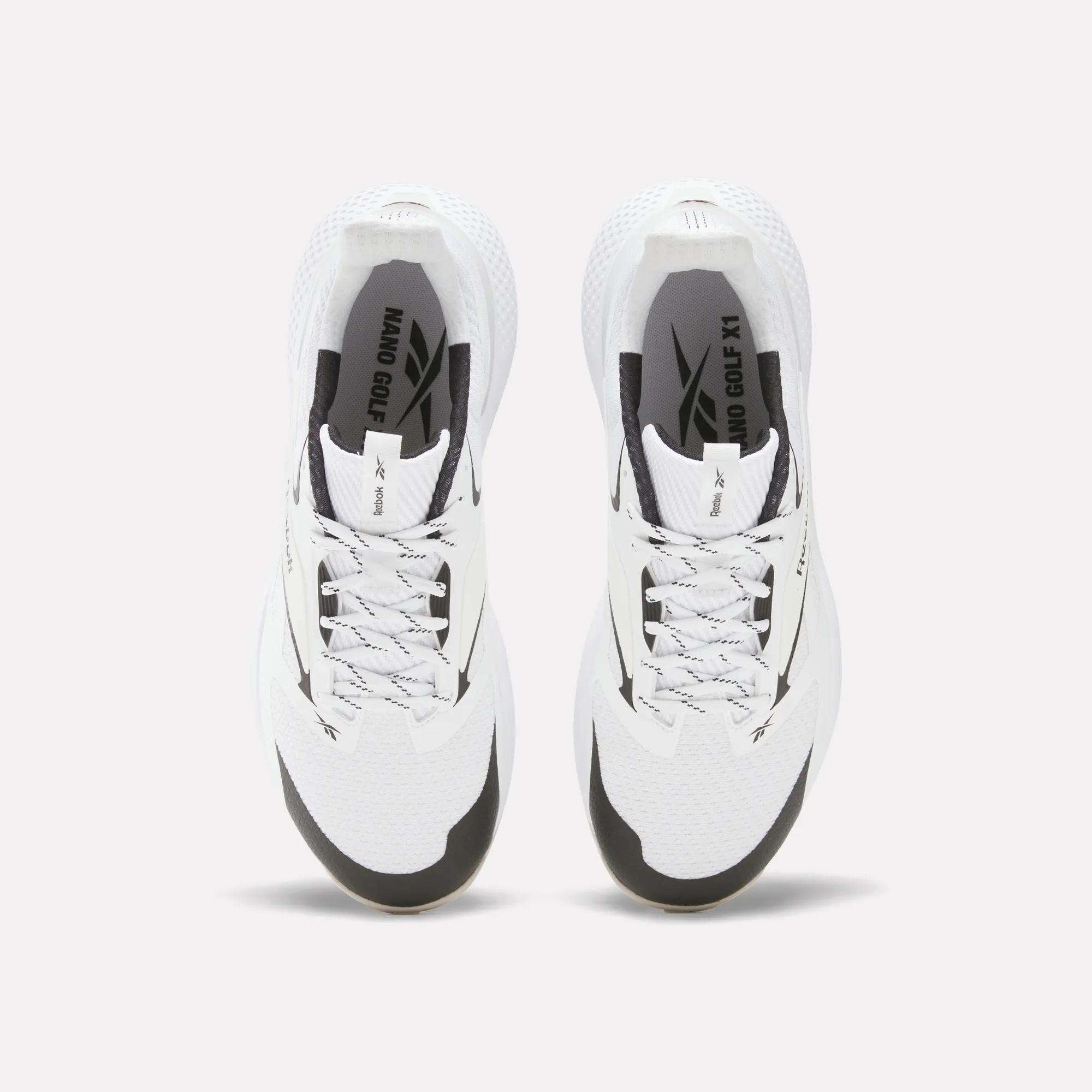 Top view of Reebok Nano Golf Shoes with black accents, gray laces, and “NANO OG X1” branding. These shoes have a durable FlexWeave upper and are displayed side by side on a plain white background.