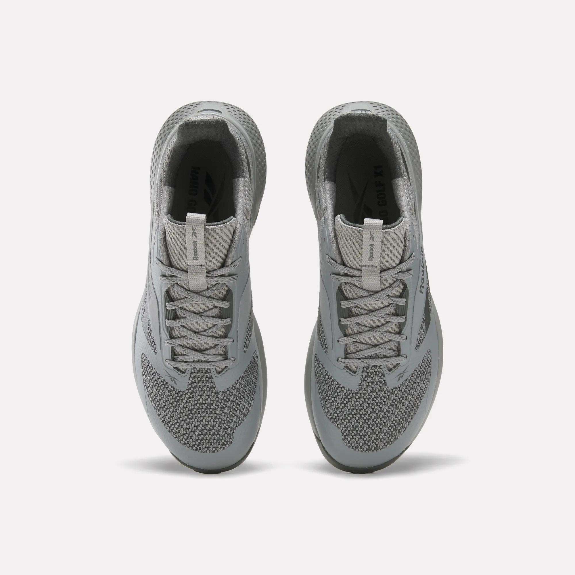 A pair of gray Reebok Nano Golf Shoes viewed from above, featuring laces, mesh texture, cushioned collars, and a lightweight FlexWeave upper for breathability and support against a plain white background.