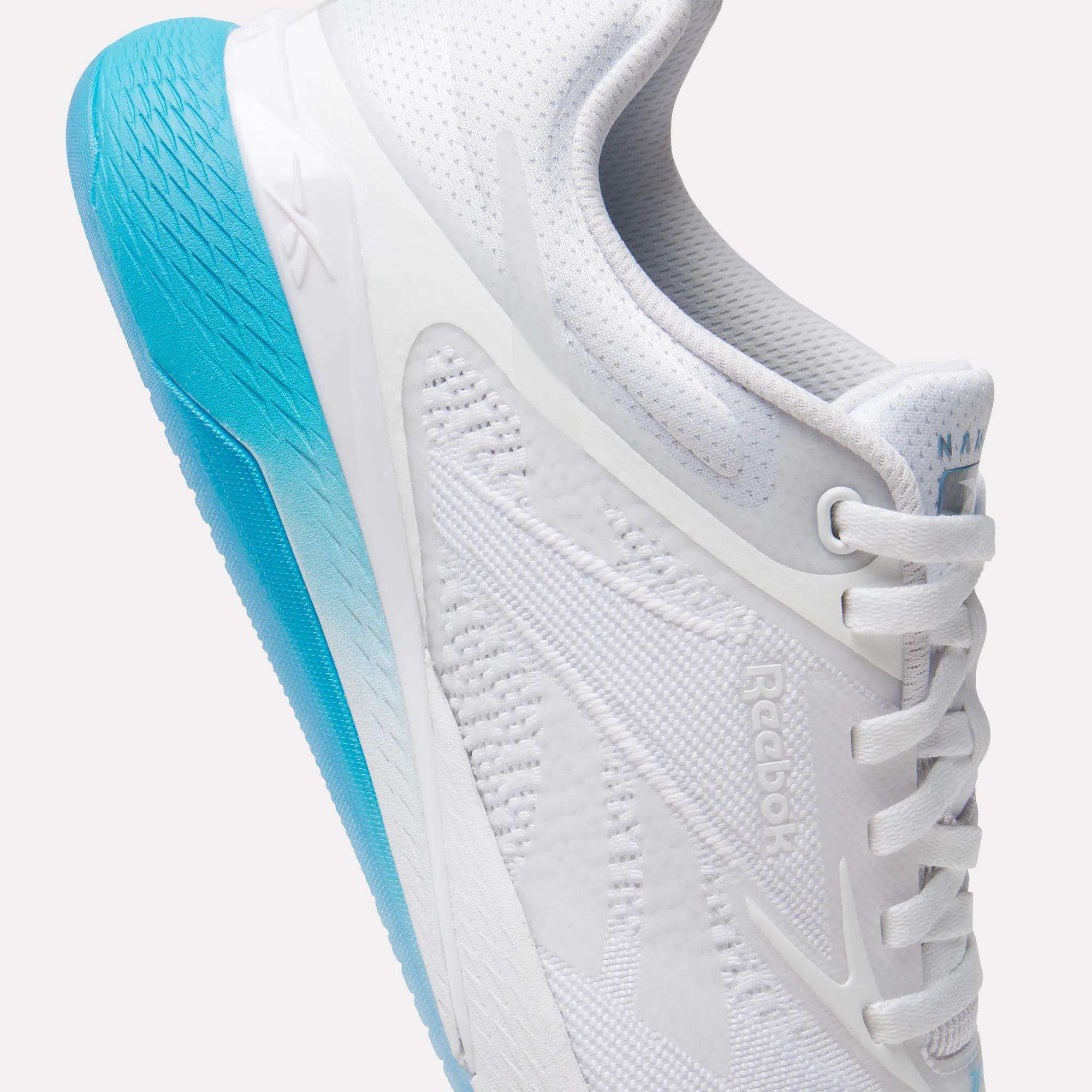 A close-up of the Reebok Women's Nano X5 Training Shoes, featuring a textured bright blue sole and white laces, shown from the side against a plain white background—ideal for those seeking stylish women's training footwear.