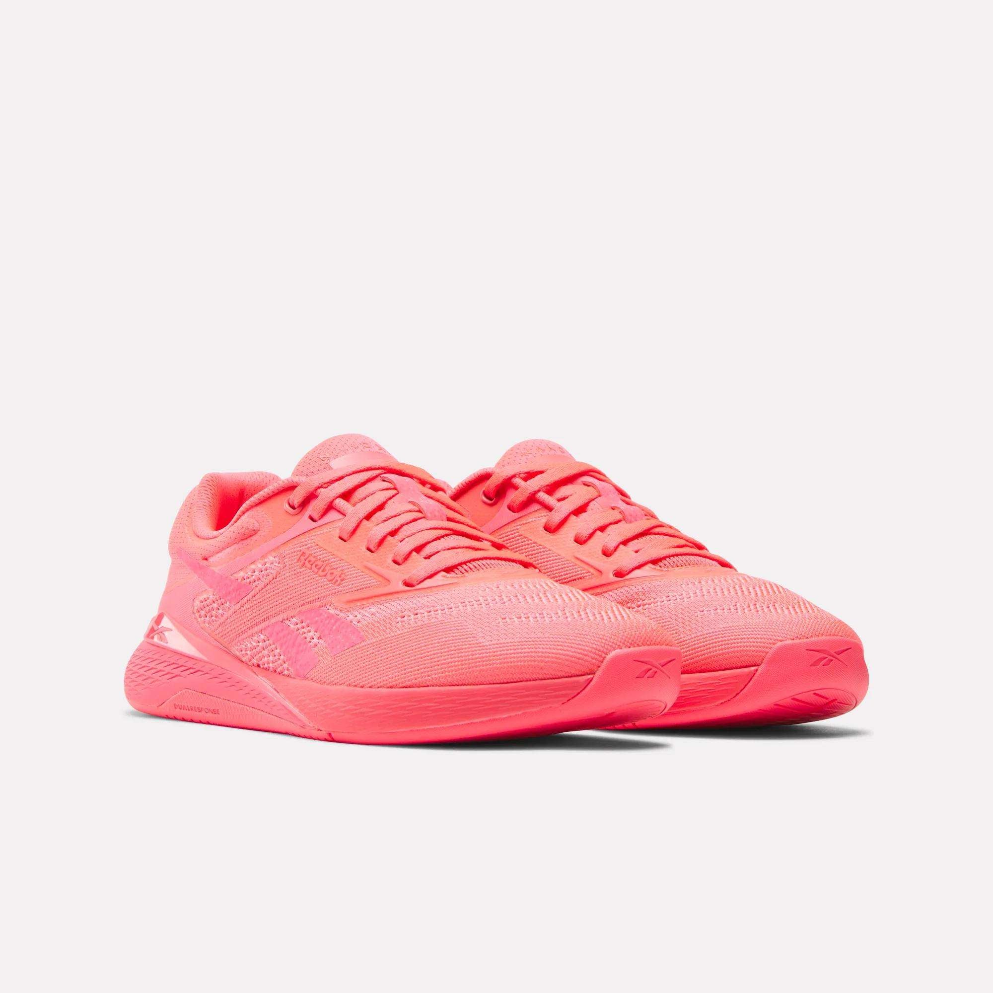 A pair of Reebok Women's Nano X5 Training Shoes in bright pink, featuring mesh uppers and rubber soles, displayed side by side on a plain white background.