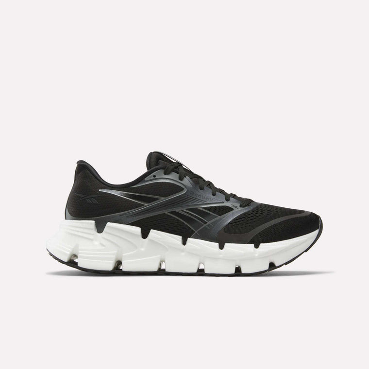 The Reebok Men's FloatZig 2 Running Shoe in black features a chunky white sole, subtle gray accents, and Superfloat+ cushioning for comfort. Shown from the side against a plain light background.