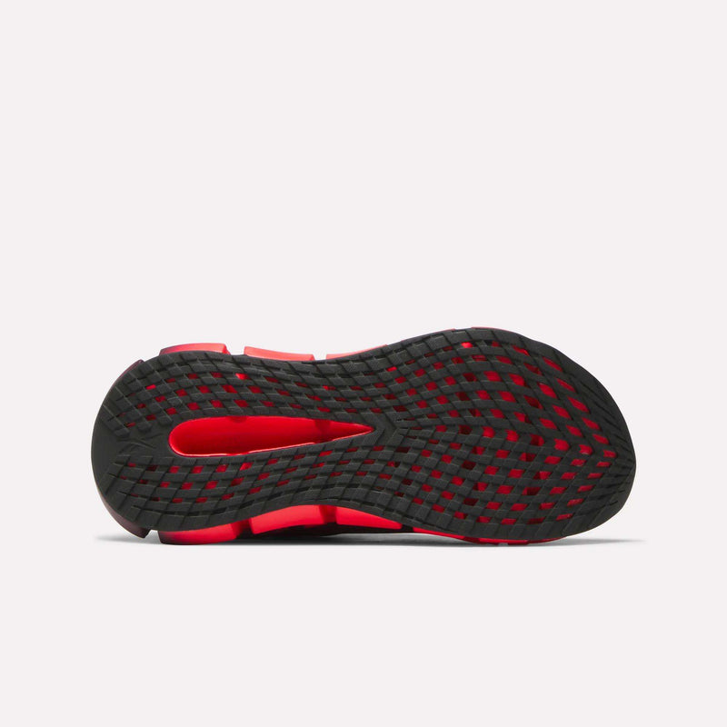 The image displays the sole of the Reebok Women's FloatZig 2 Running Shoes, mainly black with red accents and a grid-like tread. The plain light background emphasizes the Superfloat+ cushioning outsole's details.