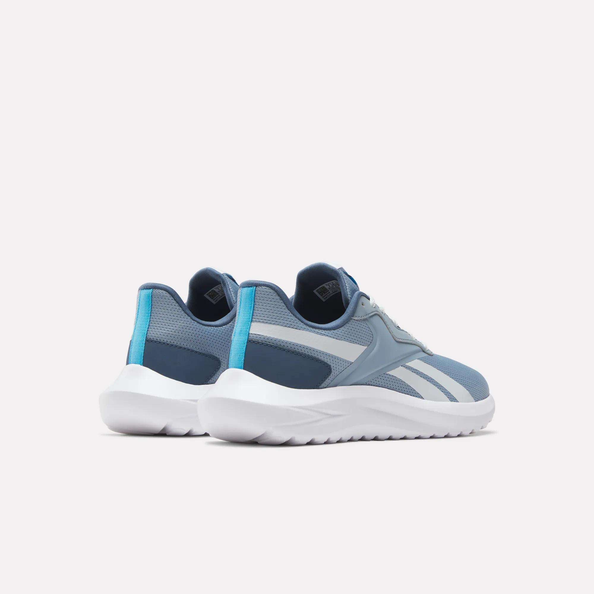 The Reebok Women's Energen Lux Running Shoes feature blue and white mesh uppers with light blue accents and white soles, shown from the back and side on a plain white background—ideal for versatile workouts.