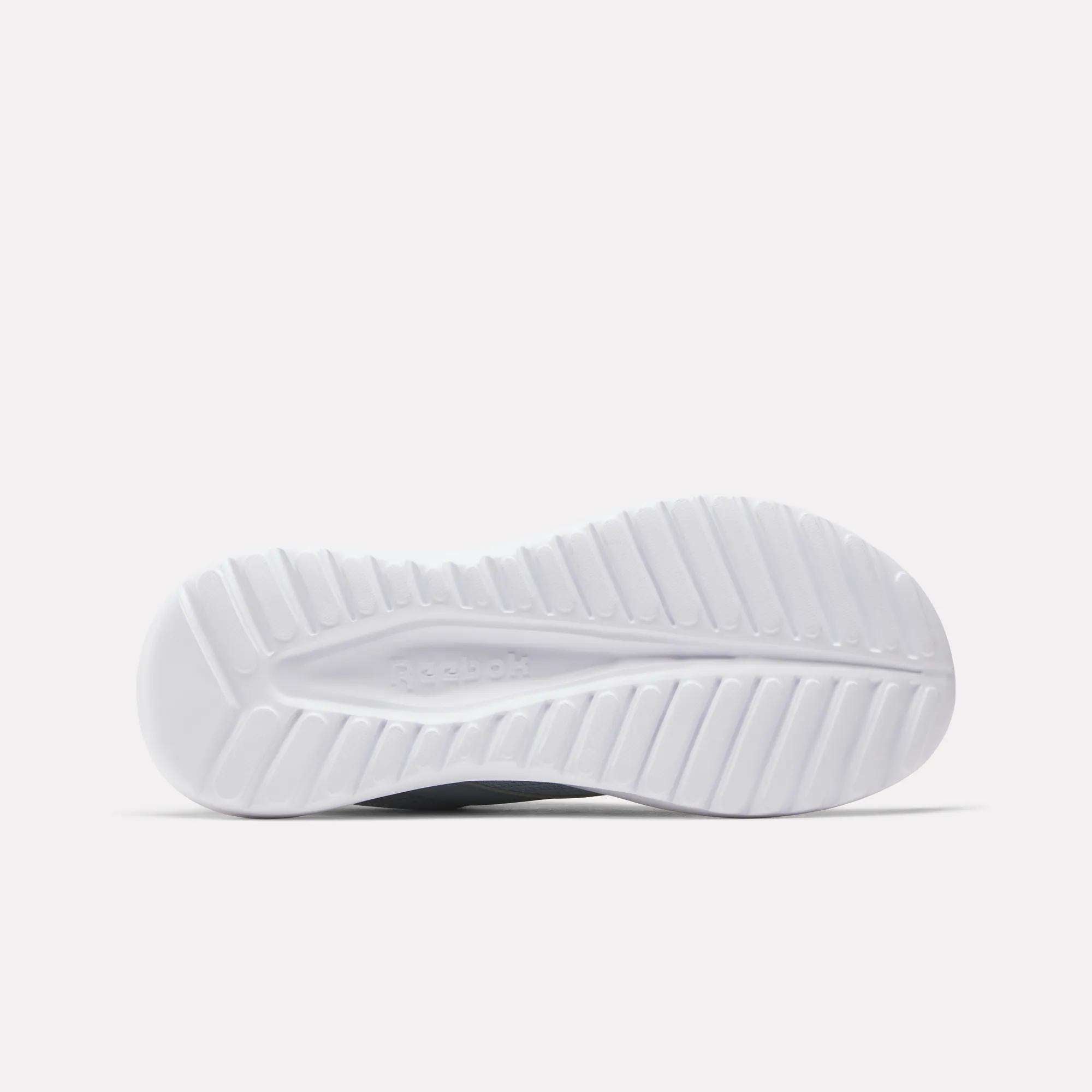 The bottom of these Women's Energen Lux Running Shoes by Reebok displays a white sole with a textured, grooved pattern for traction.